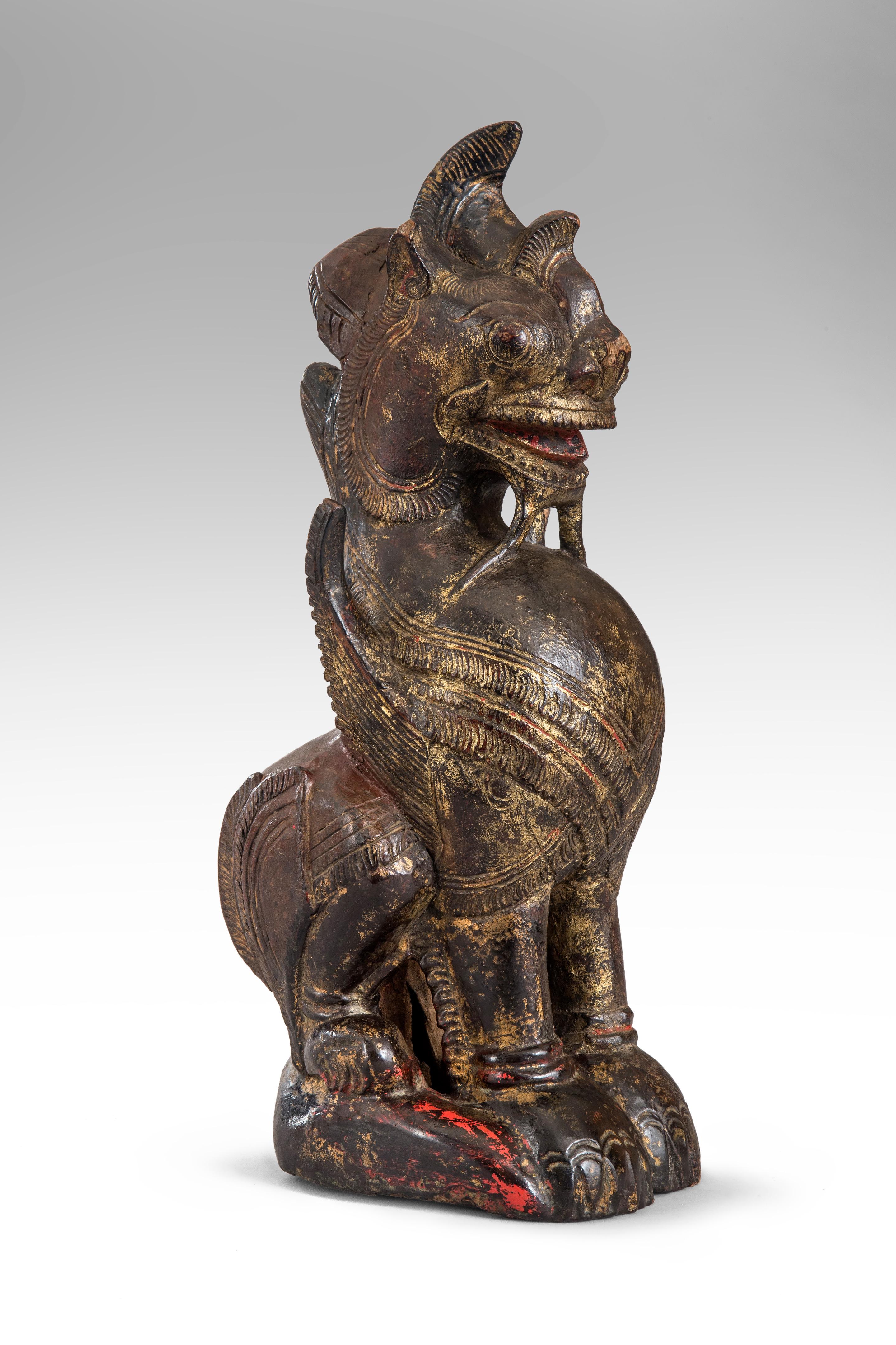 Thai mythological guardian lion sculpture
19th or 20th century.
The well carved winged figure sitting upright with aged black and red paint, traces of gilding. Small part of base missing otherwise in wonderful antique condition. The lion,