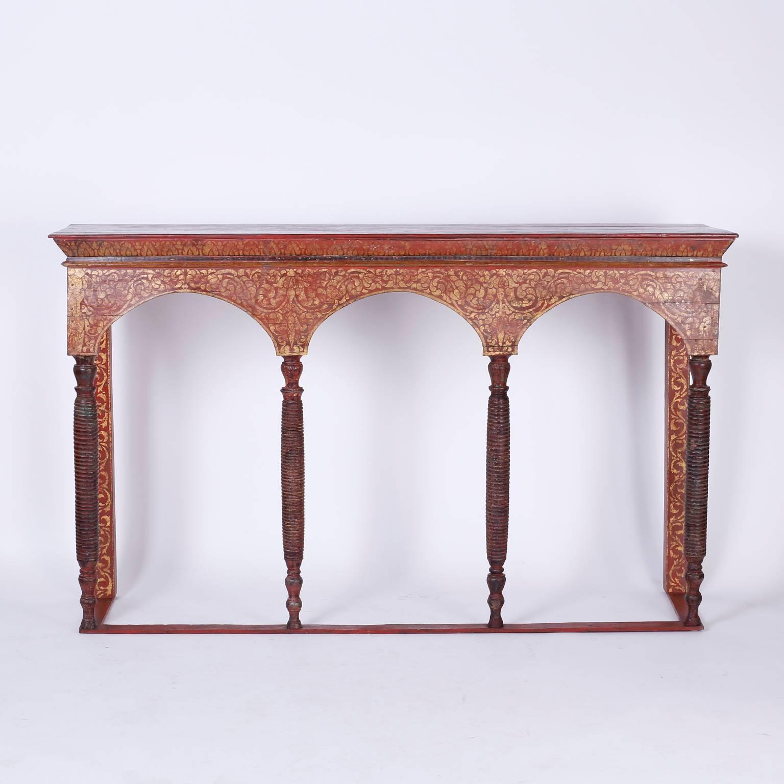 Antique Thai altar table or console with a strong architectural form. Crafted in wood with three arches supported by four turned wood columns. The table is painted in a rustic polychrome technique and
aged to perfection.