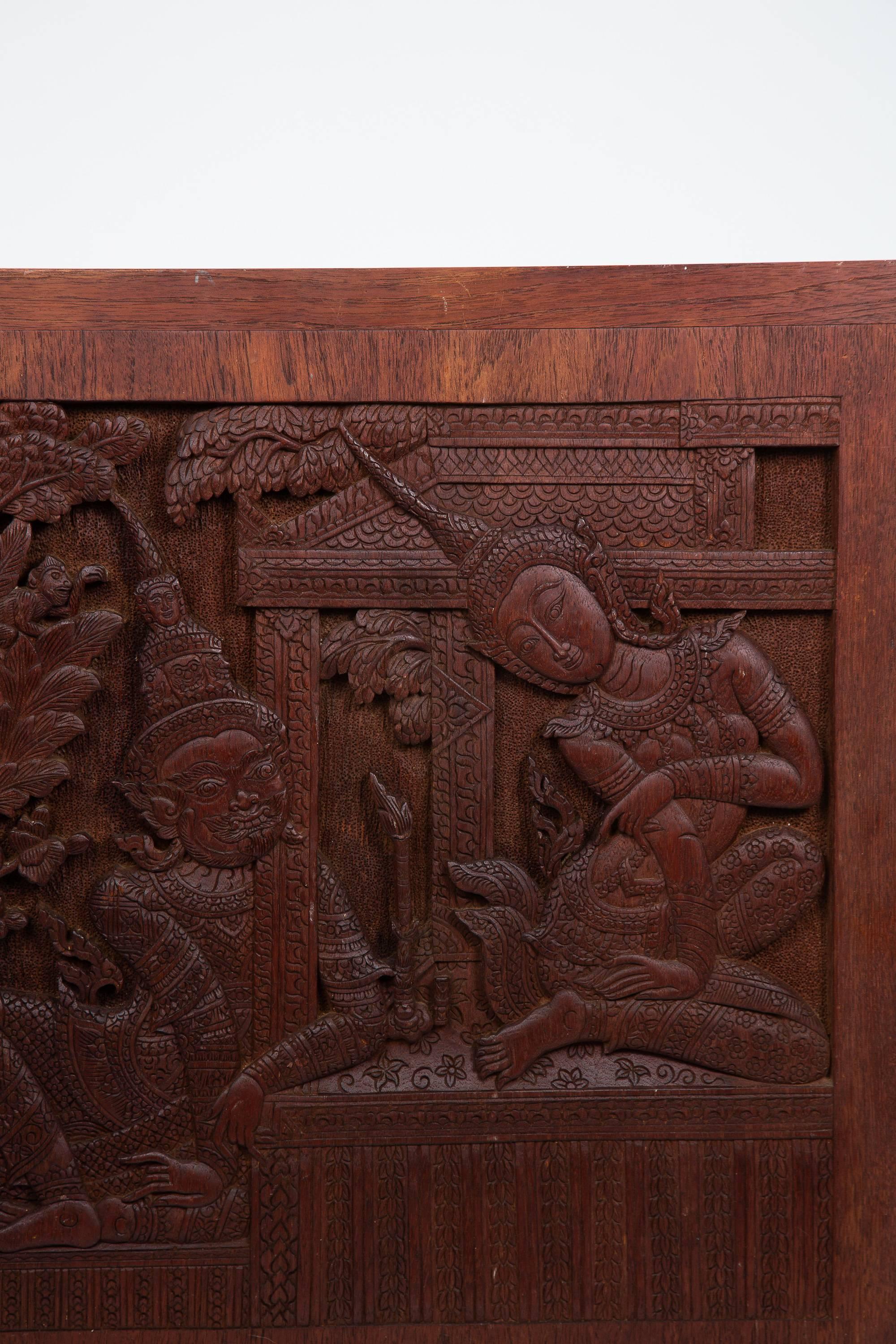 Alte siamesische handgeschnitzte Teakholztafel einer Tempelgöttin und ihres Verehrers oder Gefährten, mit fein detailliertem Hintergrund.