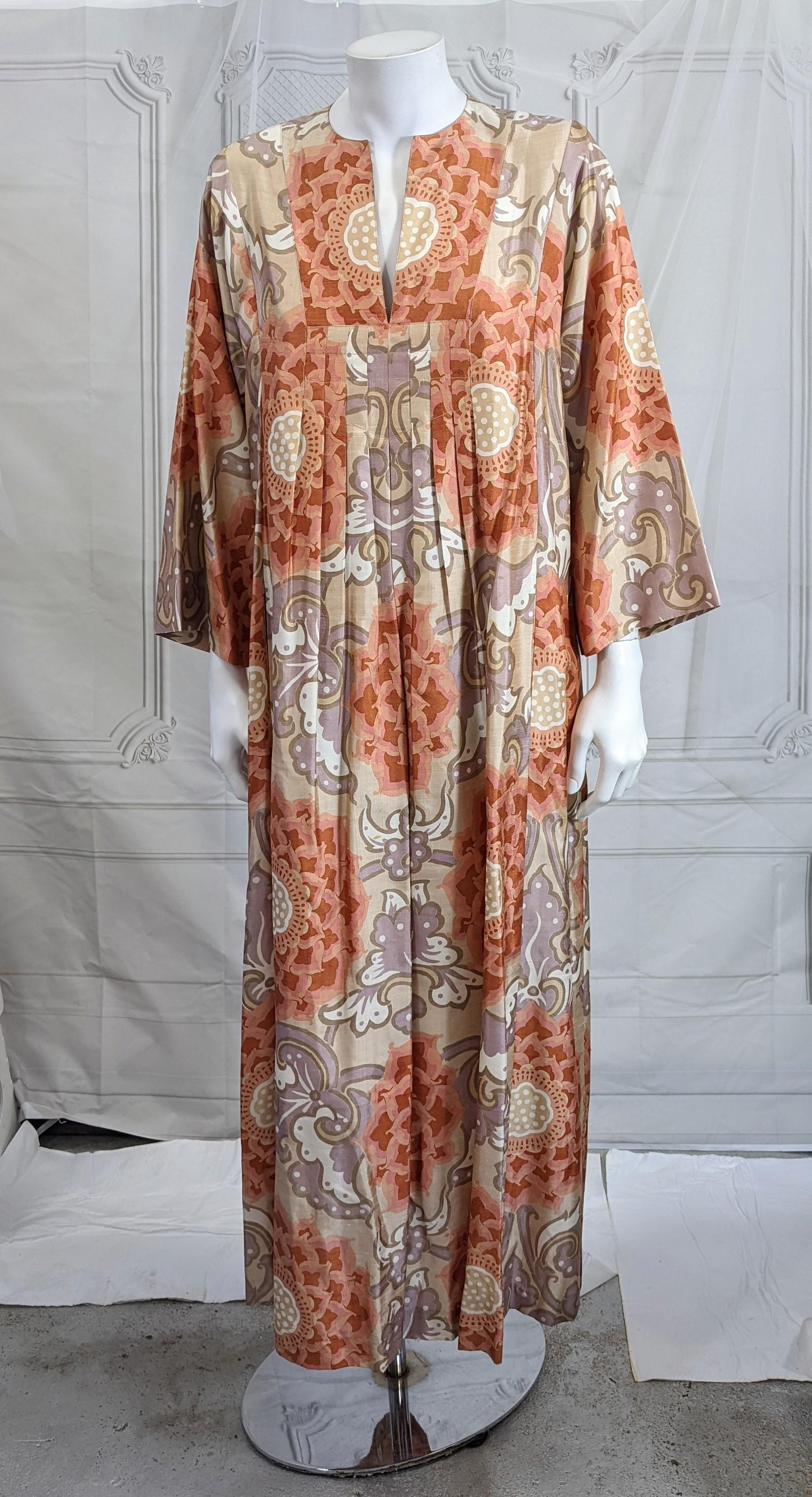 Easy and comfortable Thai Silk Caftan with front pleated detail and self belt. Pretty enough to wear as a Resort ready dress, made and imported by Jim Thompson for the American market. Wonderfully crisp silk with tonal floral lotus print. Pulls over