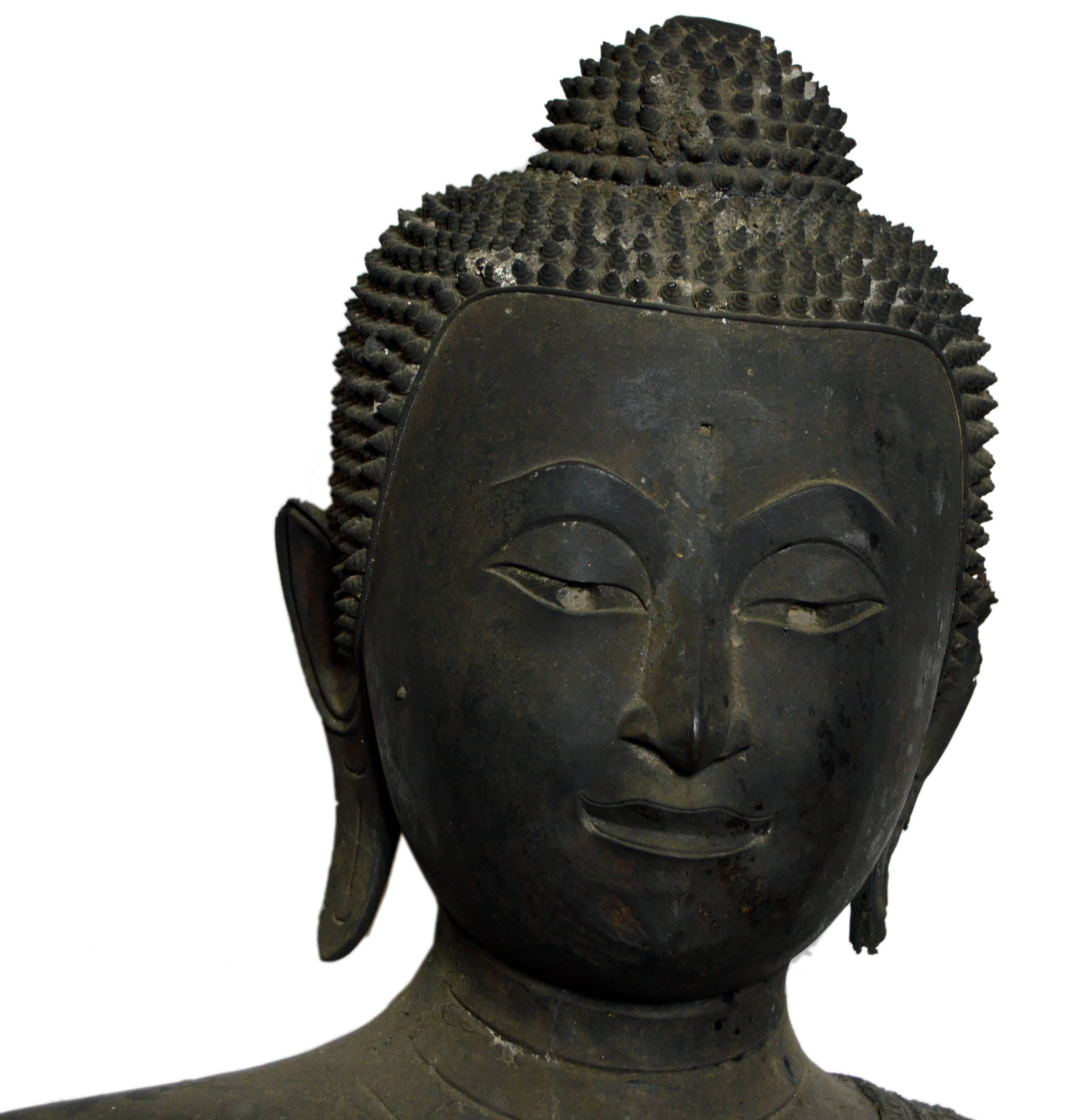 A turn of the century (19th to 20th) bronze Thai seated meditative Buddha statue with a dark patina. This Thai statue displays a seated Buddha that seems to share some similarities to the style of Buddha common in the Pala Empire in northern India
