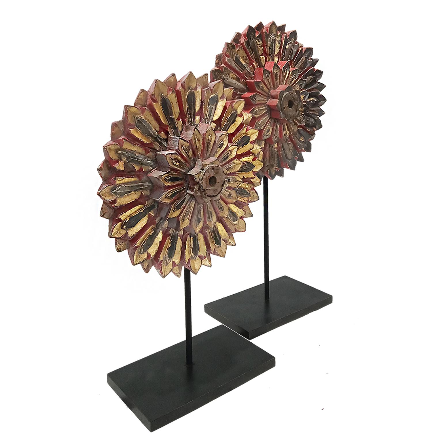Thai Flower Sculptures, early 20th Century. 

Hand-carved out of reclaimed teakwood and repurposed from wheels to flower sculptures, these pieces are a very special sample of Thai artisan craftsmanship. Painted in red and gold, with black accents