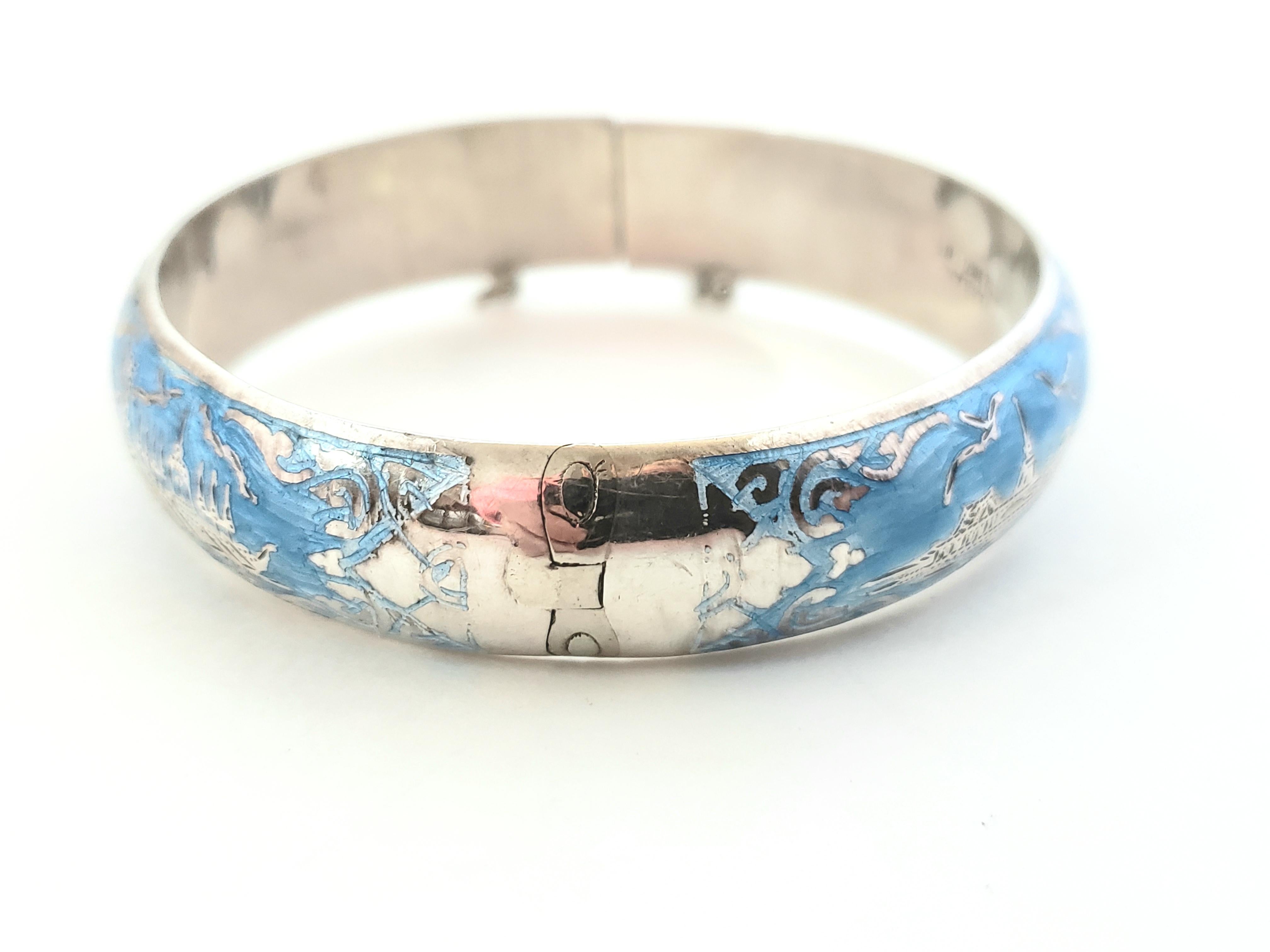 Thailand Sterling Silver Niello Blue Enamel Hinged Bangle Bracelet

This is a beautiful sterling silver Niello Blue enamel hinged bangle bracelet with etched designed. 

Measurements:     Measures 7 and 1/2 inches.  Measures 5/8
