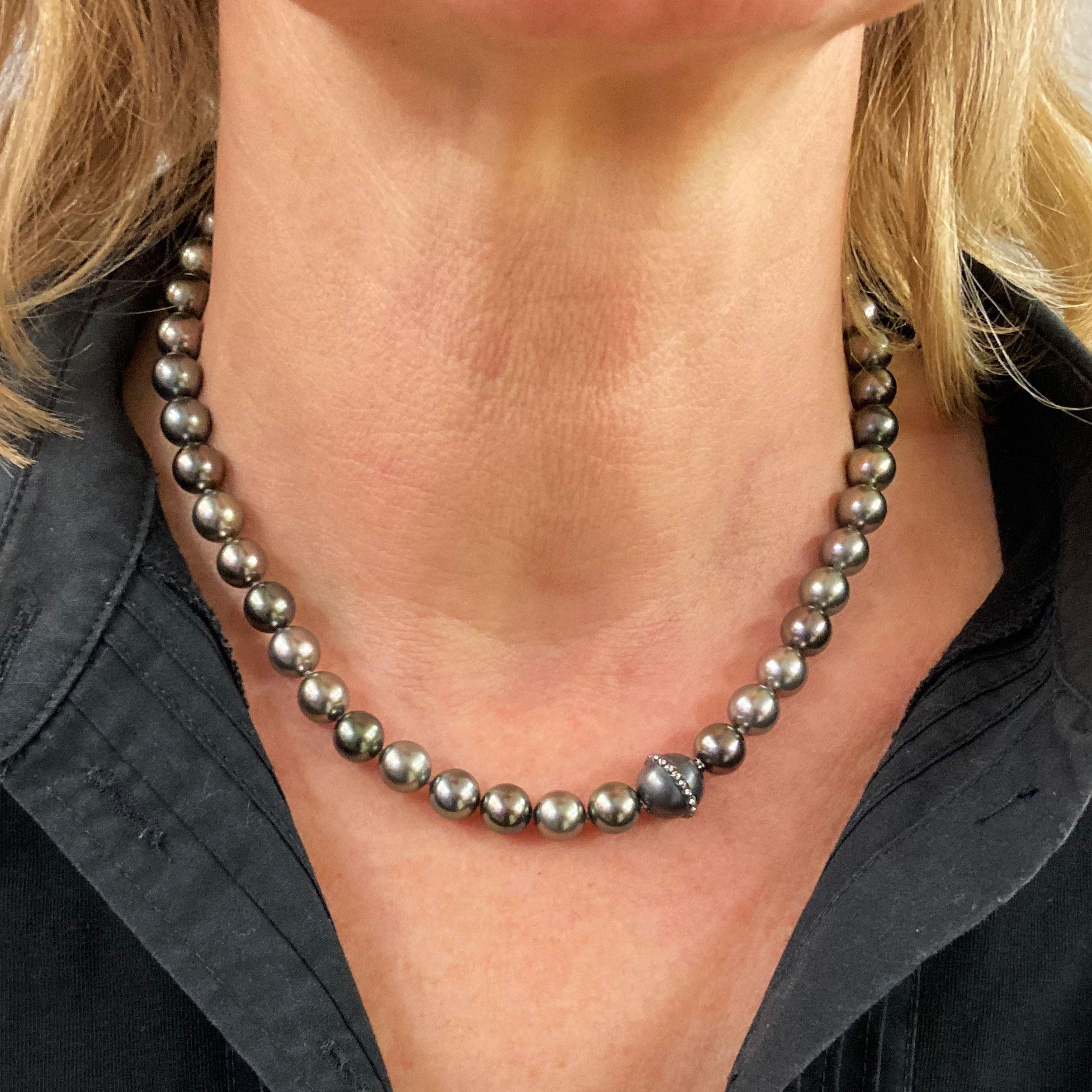 This Thaiti-Pearl-Choker Necklace shines in different grey colors.The pearls have a perfect luster.
The clasp in 18 kt white gold is finished with black rhodium and decorated with 36 Brillants with a total weight of 0.16 ct G vvs pave setted.
Total
