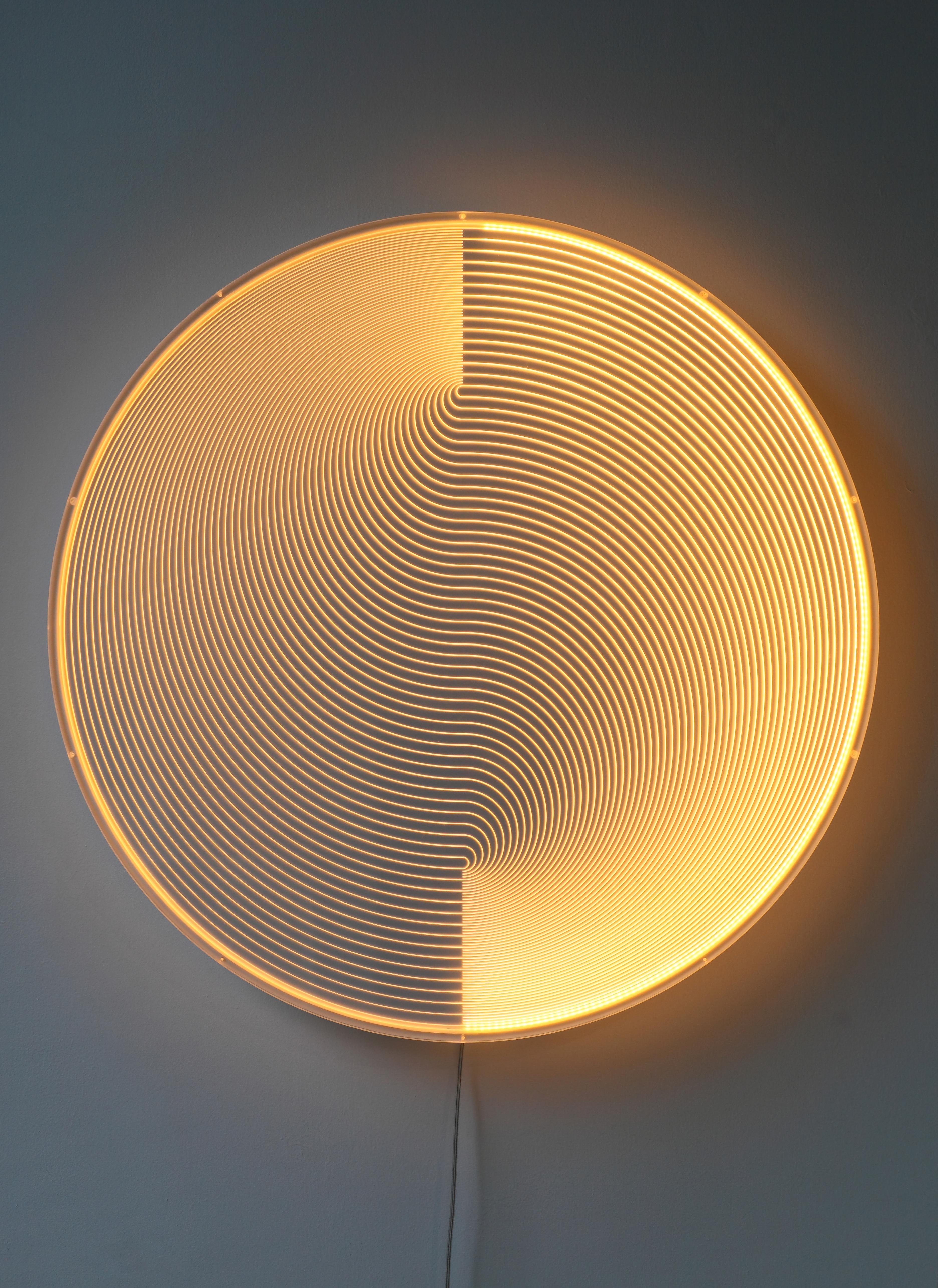 The emitting sculpture appears as a real-time light paintings, the lines of light seem to be floating in the space. A plate of acrylic glass is engraved with a pattern that creates in illusion of depth. In the same way as in fiber optics the light