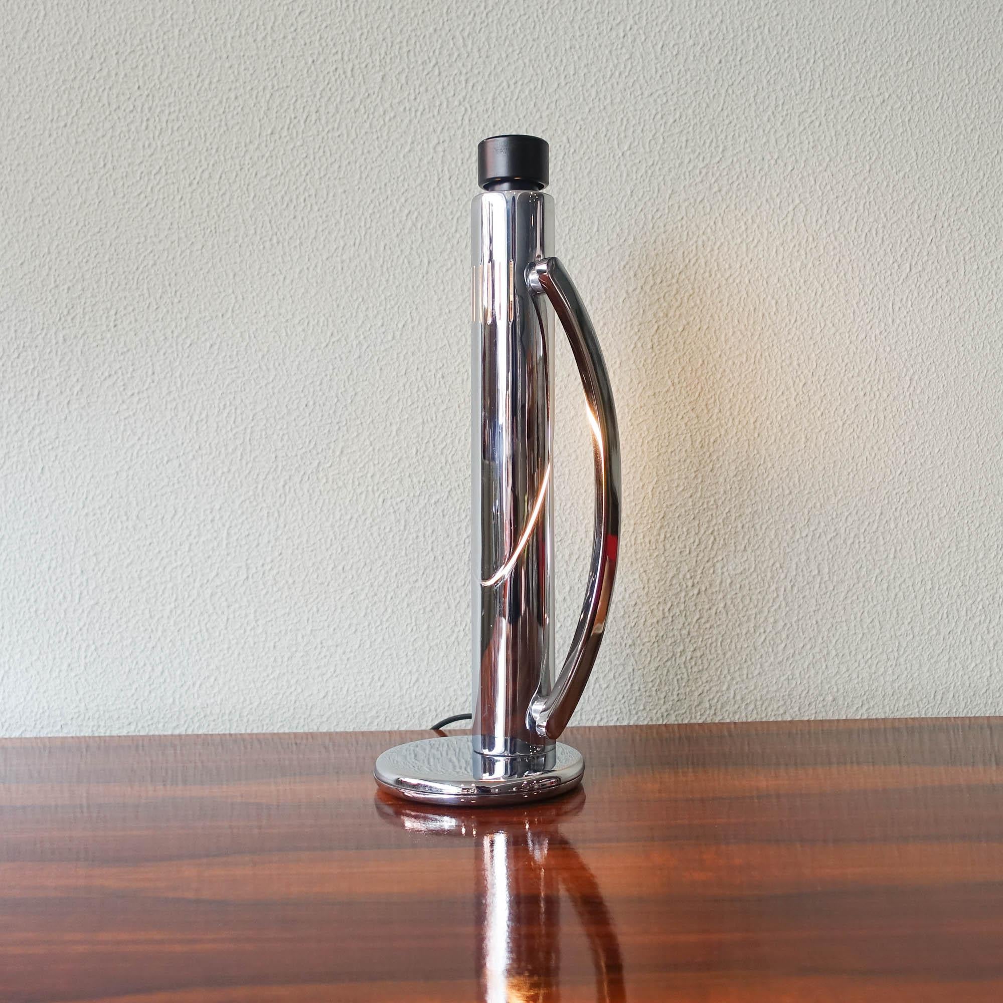 This Table Lamp, model Tharsis, was designed by Luis Perez de la Oliva and produced by Fase, in Spain, in 1973. It has a round chromed metal base (iron). 2 chrome cut tubes, painted off white inside. The lampshade part is perforated. Black round