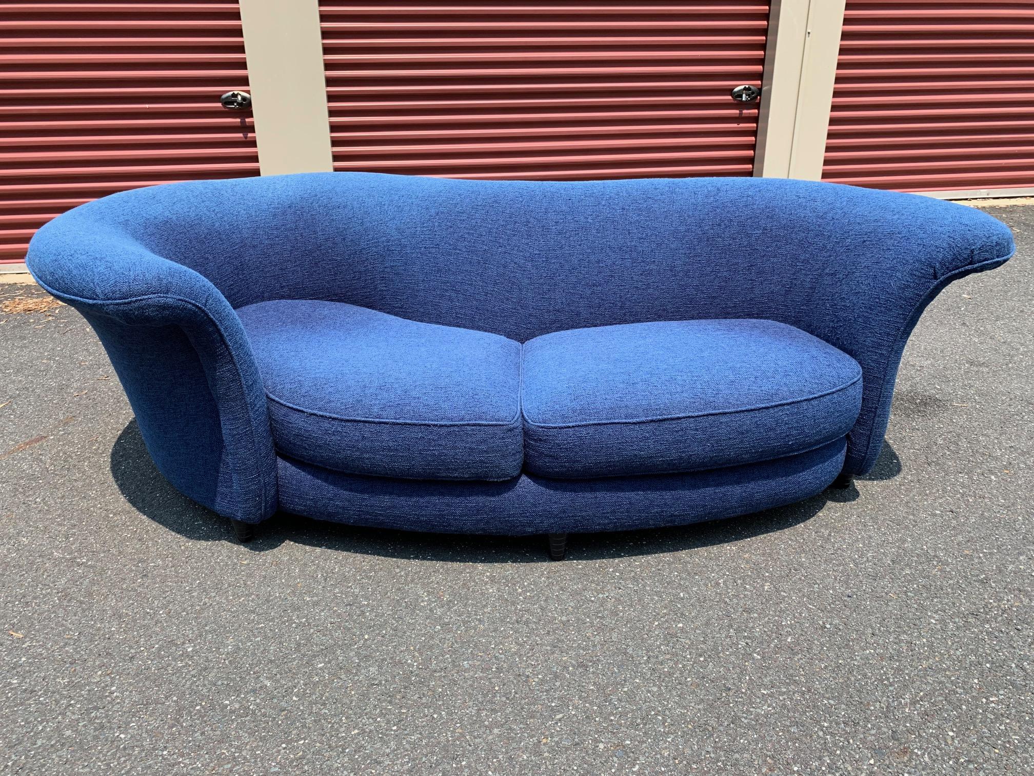 A curvy sculptural serpentine sofa. From the Prodigy line by Thayer Coggin no longer in production, this dramatically shaped sofa features a shelter style frame designed to nest your body maximizing comfort. 
The top of the sofa features a flare