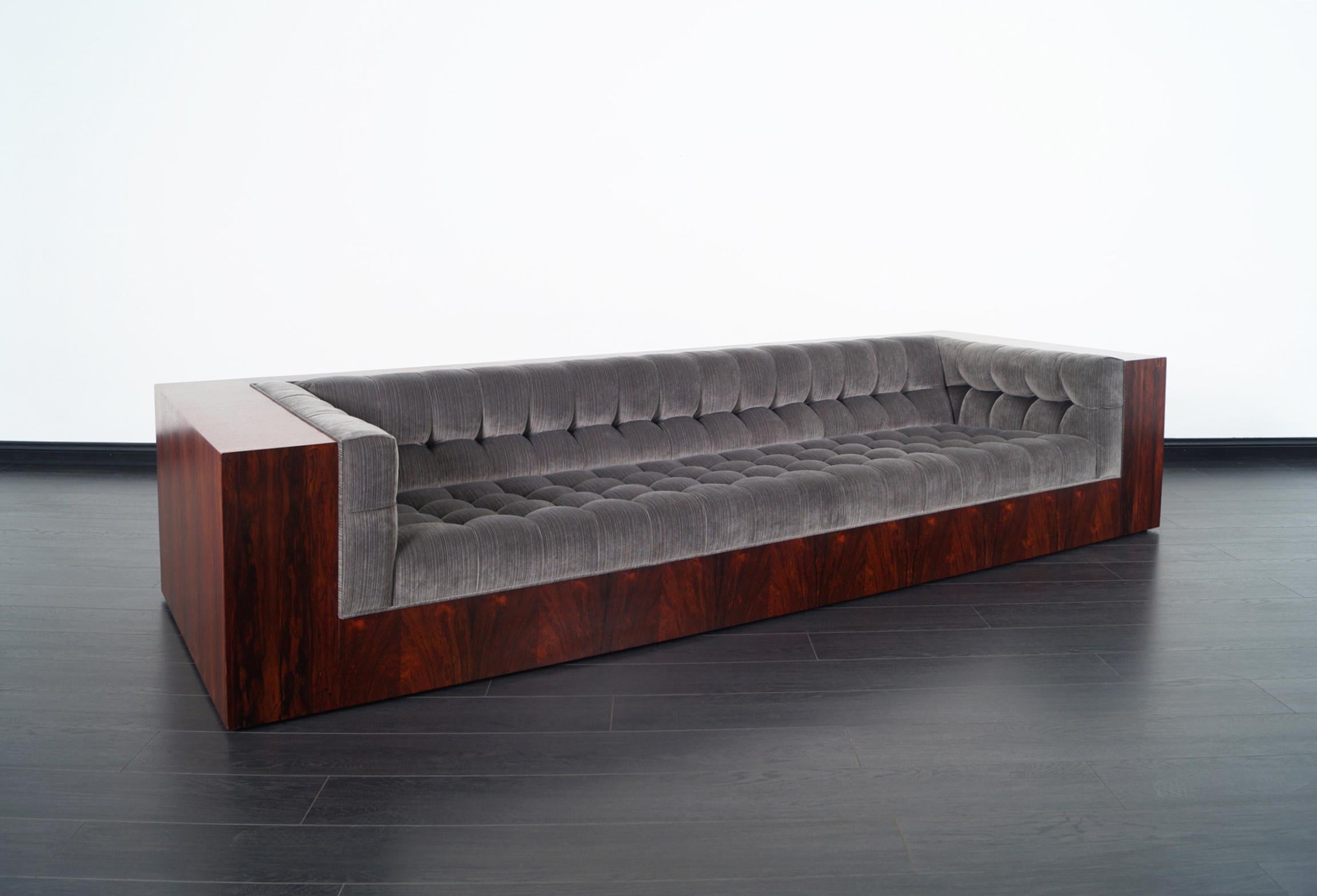 Incredibly stunning vintage rosewood sofa designed by iconic designer Milo Baughman for Thayer Coggin. This exceptional sofa exposes extraordinary Brazilian rosewood grain. Newly reupholstered in custom biscuit tufted upholstery in fine velvet. Top