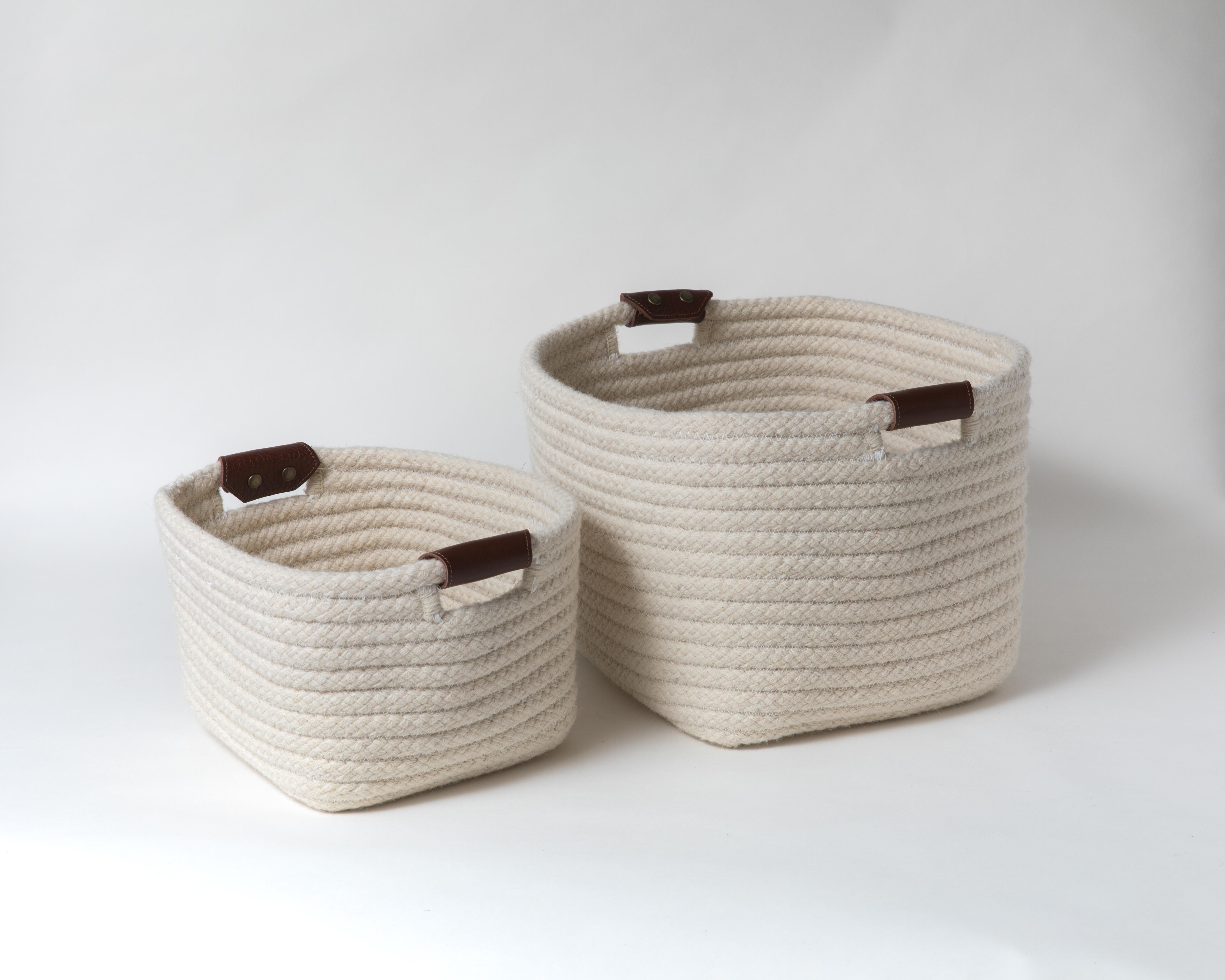Simple and sturdy woven basket in a rectangular design. Cream, natural un-dyed wool is accented with leather handles. Handle color options are brown, black and natural. 

Designed by Meredith Thayer in her South Boston studio and made to order in