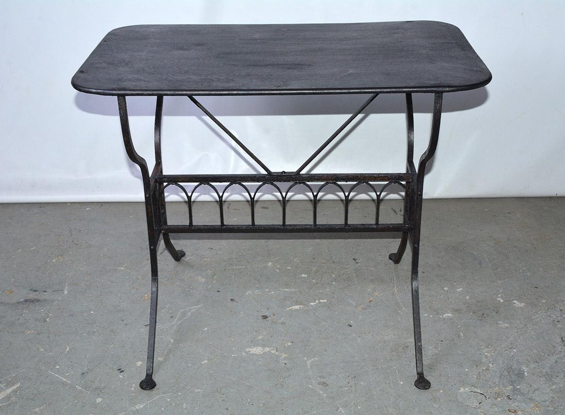 The 19th century French iron garden table is painted black and has a row of faux gothic arches embellishing the stretcher that secures splayed legs. The top is also made of iron. Most certainly sturdy enough for potted plants, porch use and also the