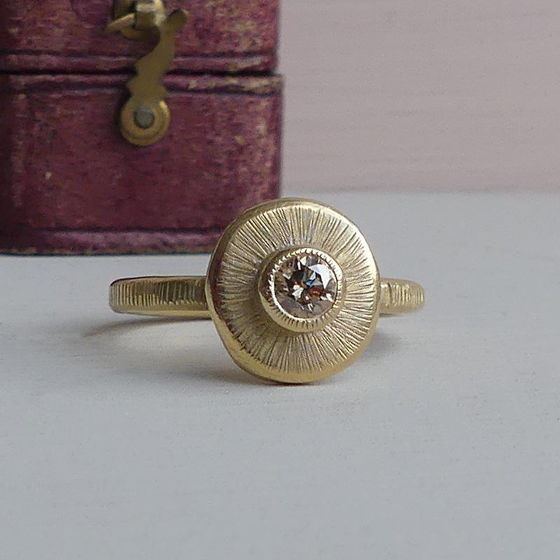 The Amanita handmade ring has a delicious 0.20 carat pale chocolate diamond set into a hand rolled nugget of Fairmined gold with hand-stamped lines.  

She is a  strikingly beautiful ring and an artisanal piece that tells a story.  Amanita is