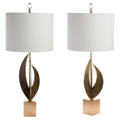 La lampada ad arco è composta da 3 pezzi in bronzo fuso montati su un basamento in ottone color oro.