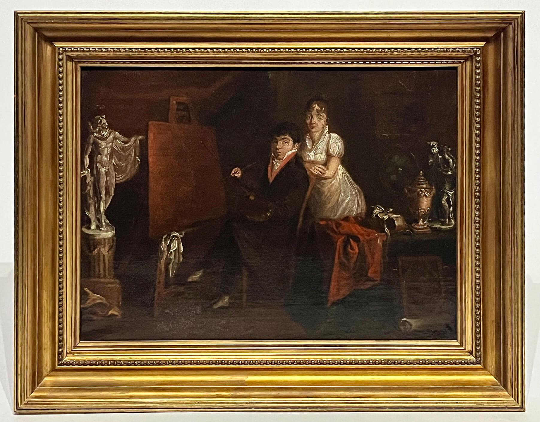 A wonderful circa 1810 Italian school oil-on-canvas painting of an artist or painter in his studio seated legs-crossed in a chair facing the canvas on easel with palette and brush in hands, a female attendant, presumably his wife or model, props