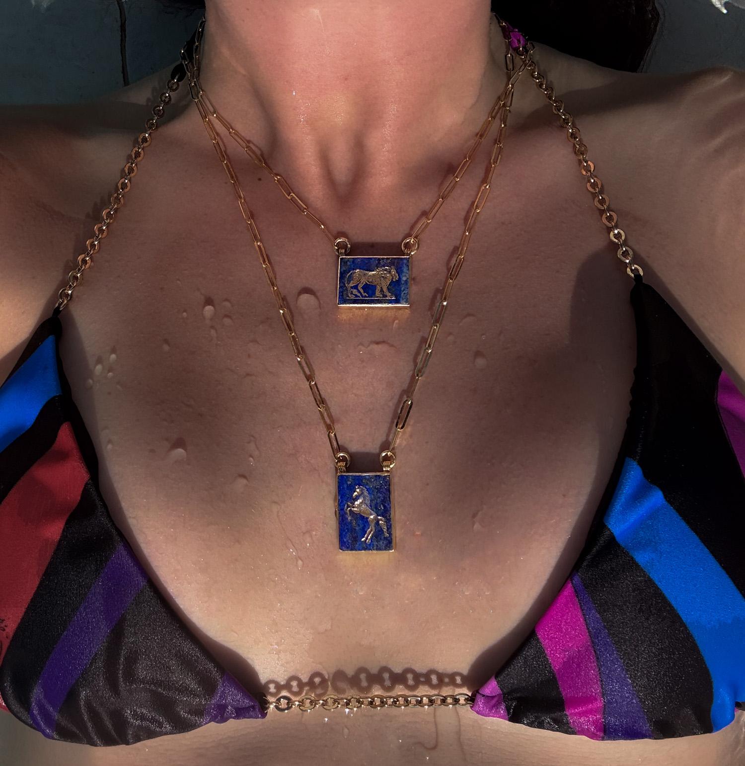Die Aslan II Halskette versprüht einen königlichen Charme. Im Mittelpunkt steht eine Löwenfigur, die von Hand in einen Lapislazuli-Edelstein graviert wurde. Diese fesselnde Darstellung des majestätischen Löwen in 22-karätigem Gold Vermeil auf 925er