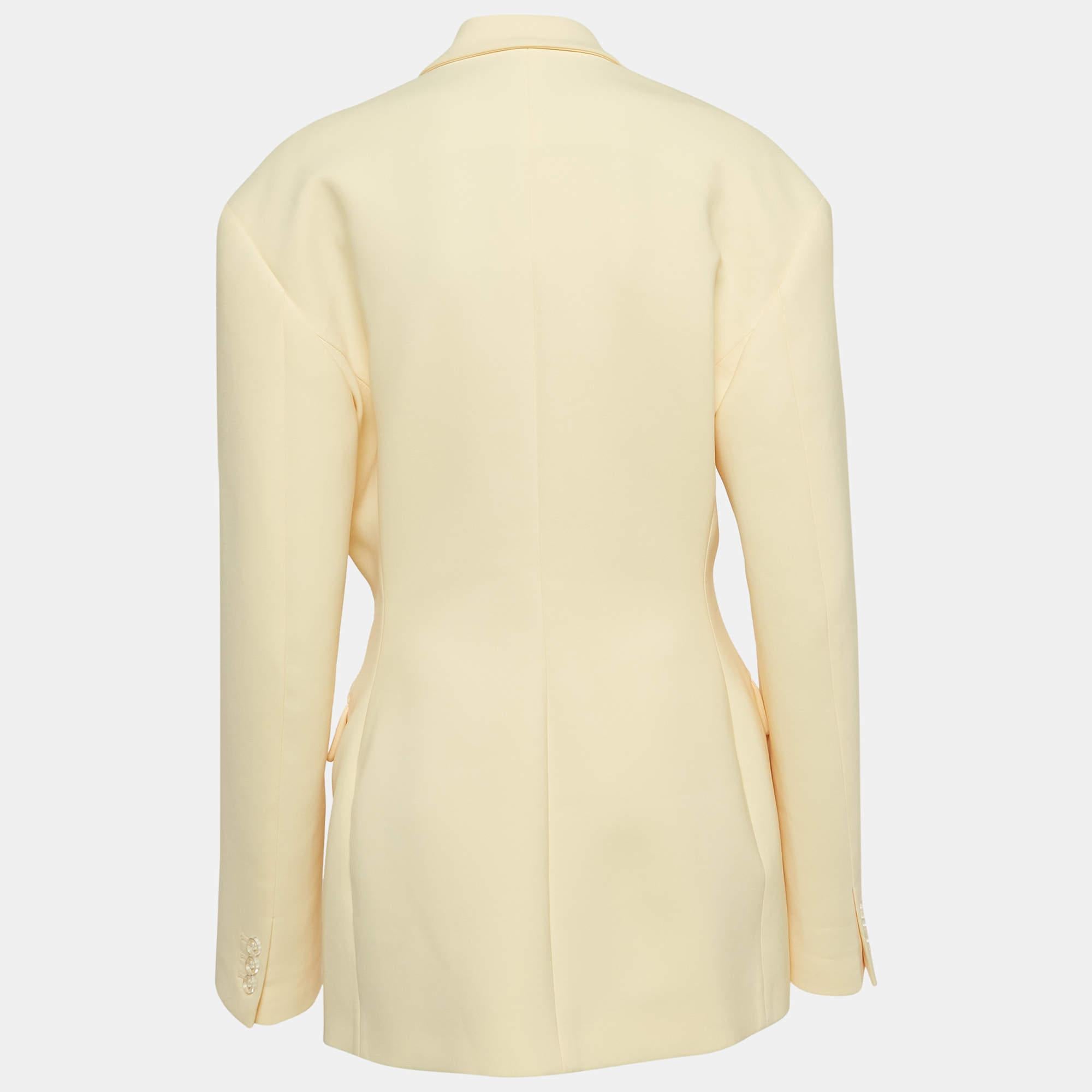 La teinte jaune pastel et la forme élégante font de ce blazer The Attico pour femme une pièce convoitée. Il a des manches longues et se ferme sur le devant par un double boutonnage. Portez-la pour un look chic sans effort.