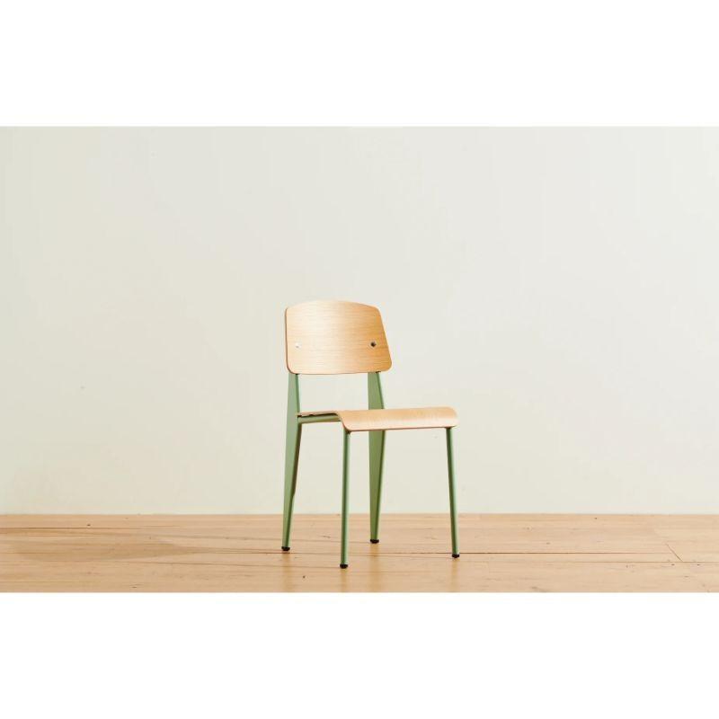 The authentic standard chair in natural oak and mint color by Jean Prouvé is as durable as it is comfortable with its mix of mint green steel base and natural oak seat.

Metal worker turned iconic yet self-taught designer and architect, Jean