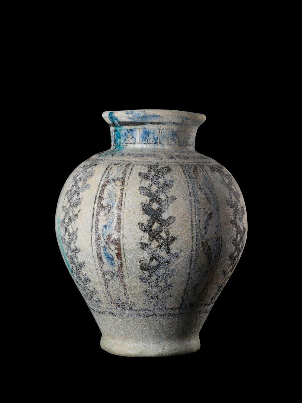 A baluster-shaped ceramic vase with siliceous paste painted in manganese and cobalt, under a transparent glaze. With hand painted blue and white decorations. Stone paste or ‘fritware’ vessels with lustre, turquoise, white and cobalt blue glazes were