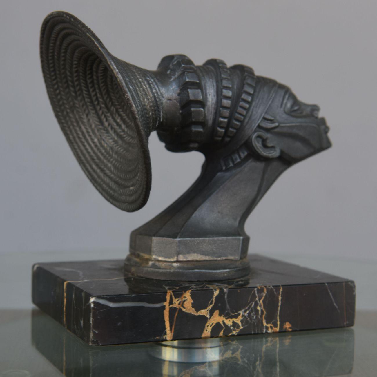 The Black Cruise by François Victor Bazin (1897-1956) mascot (radiator cap) in good standing representing a stylized bust of a Mangbetu Woman, mounted on a portor marble base, measures: height 13.2 cm. The black cruise is an automobile expedition