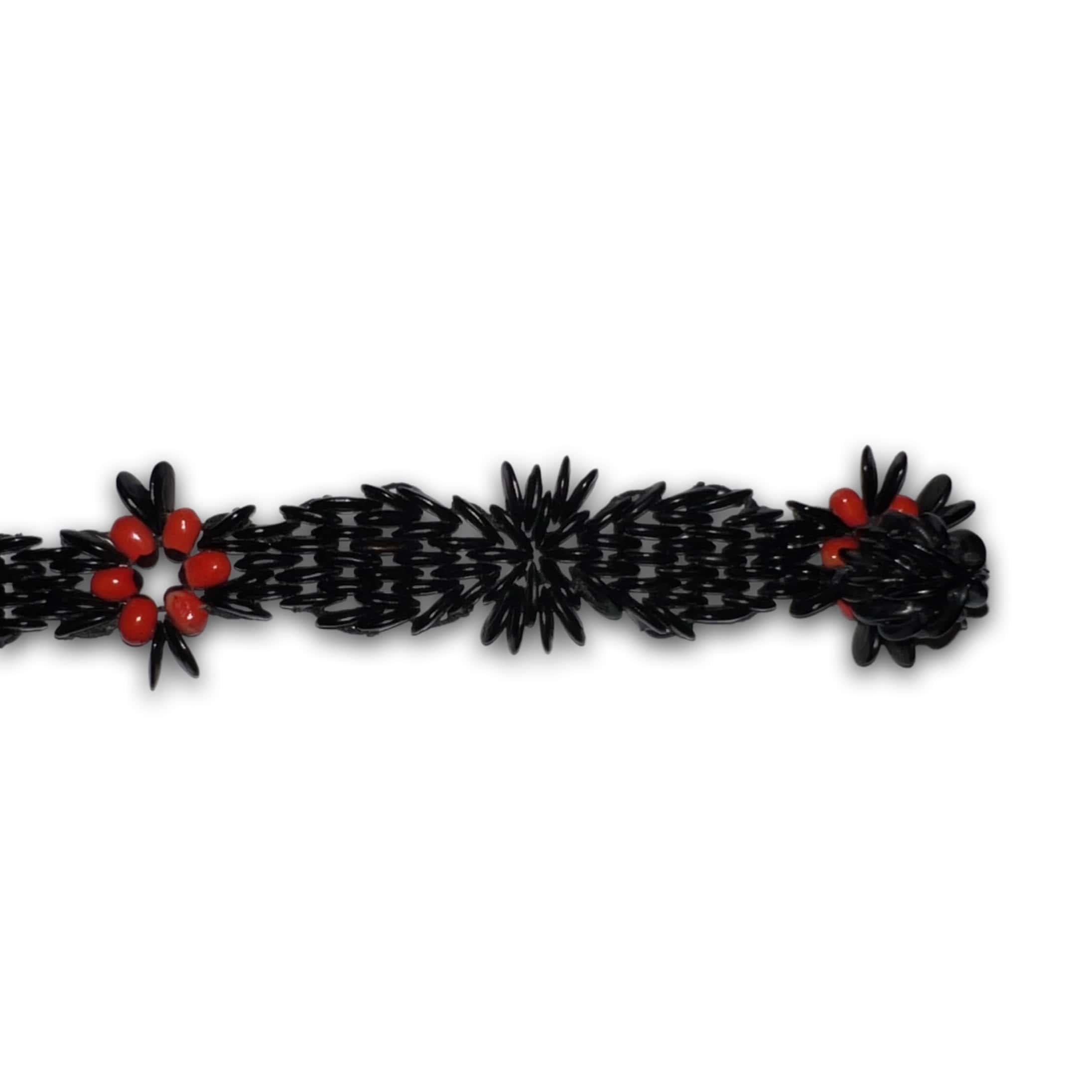 This unique 8” x .5” bracelet is inspired by the flag of Antigua and Barbuda and the Pan-African Flag. The wild tamarind seeds dyed black represent the black in both flags symbolizing Black peoples.

In contrast, the intricate tamarind seed patterns