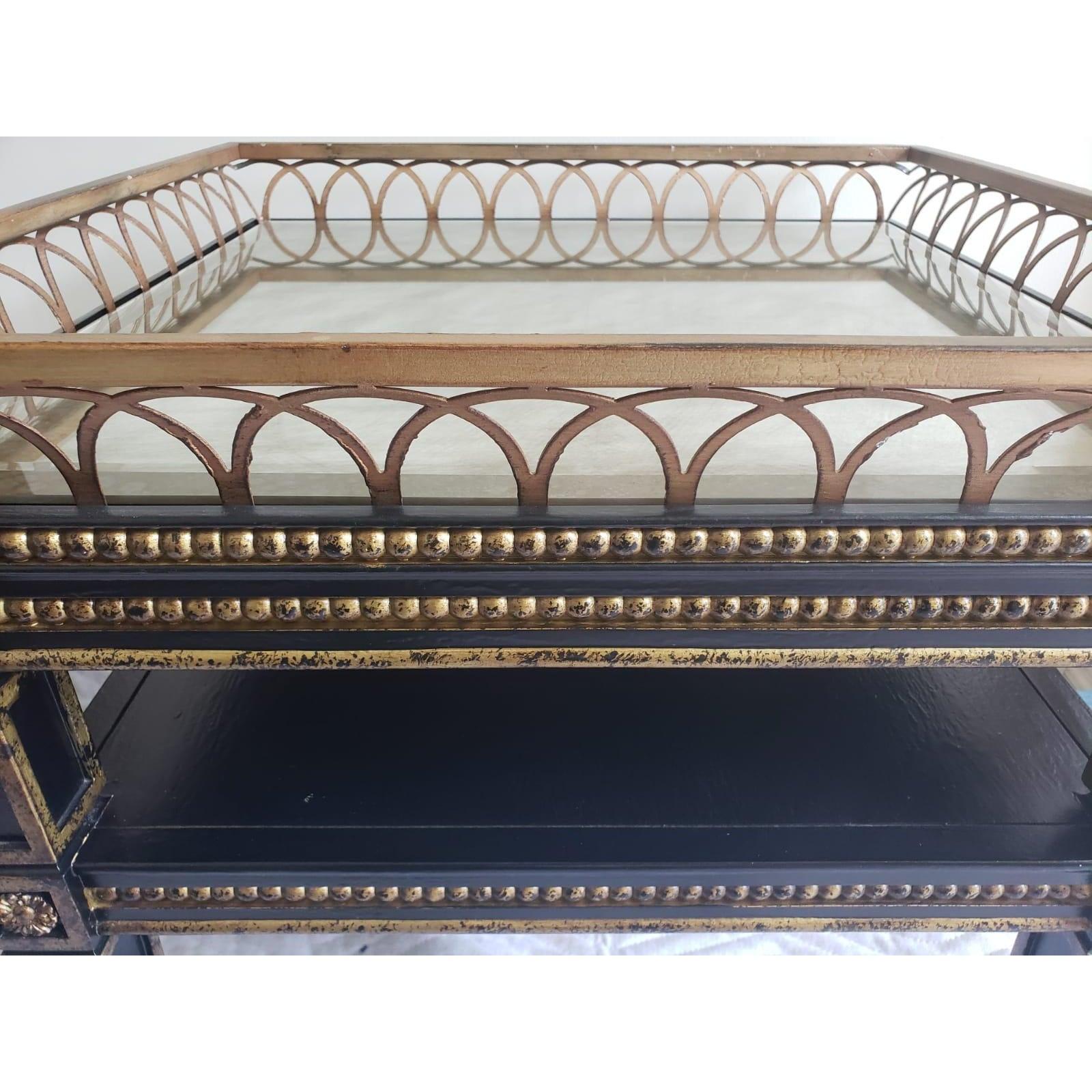 Two tier vintage neo classical giltwood frame side table, center table, topped with a golden metal ring and covered with a distressed and fogged mirror by design. Mirrored top is removable and in excellent condition.
Table measures 24