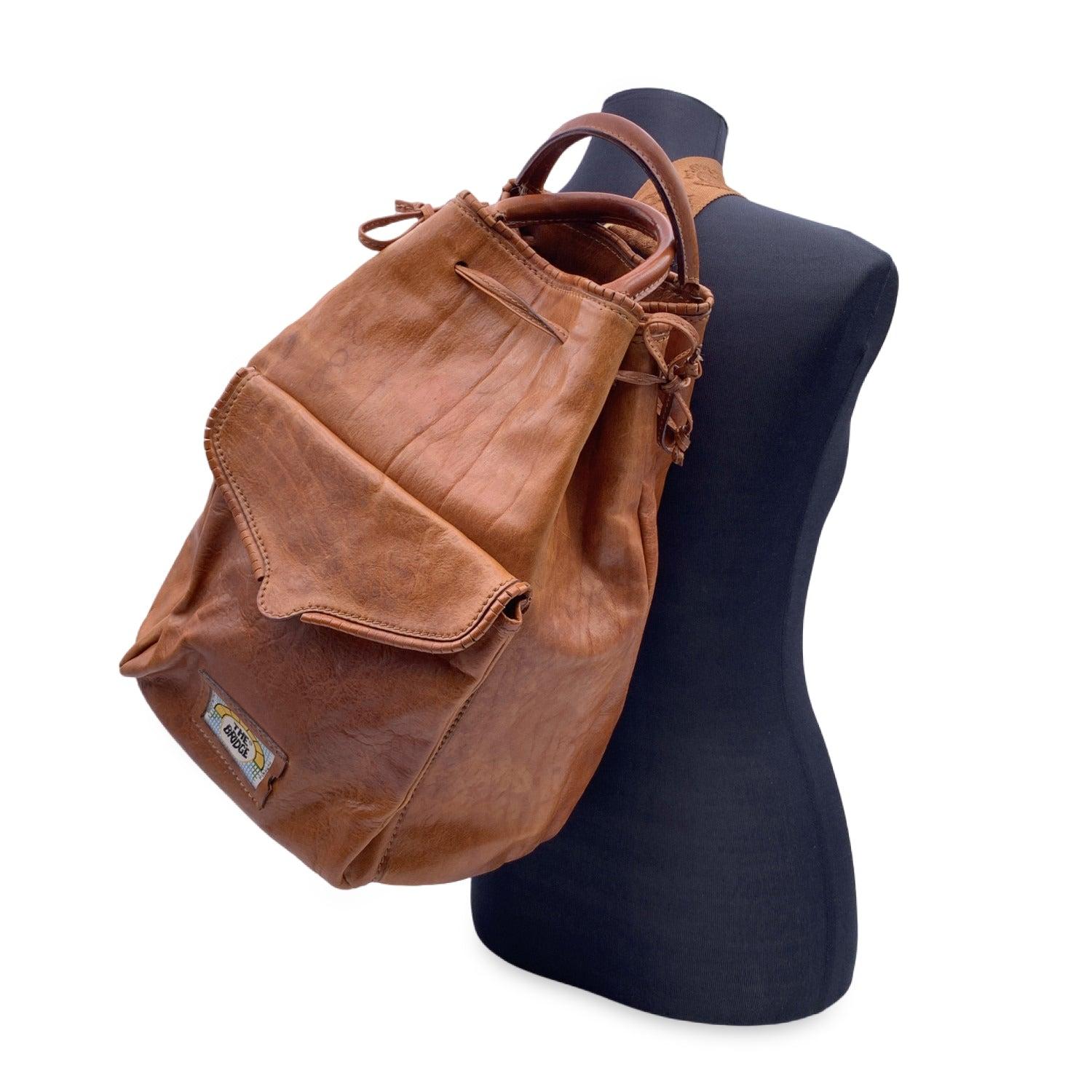 Vintage The Bridge brown leather backpack. Drawstring closure on top. 1 front flap pocket. Adjustable single shoulder strap and double top carry handles. Unlined. 1 side zip pocket inside. The Bridge tag inside Condition B - VERY GOOD Gently used.