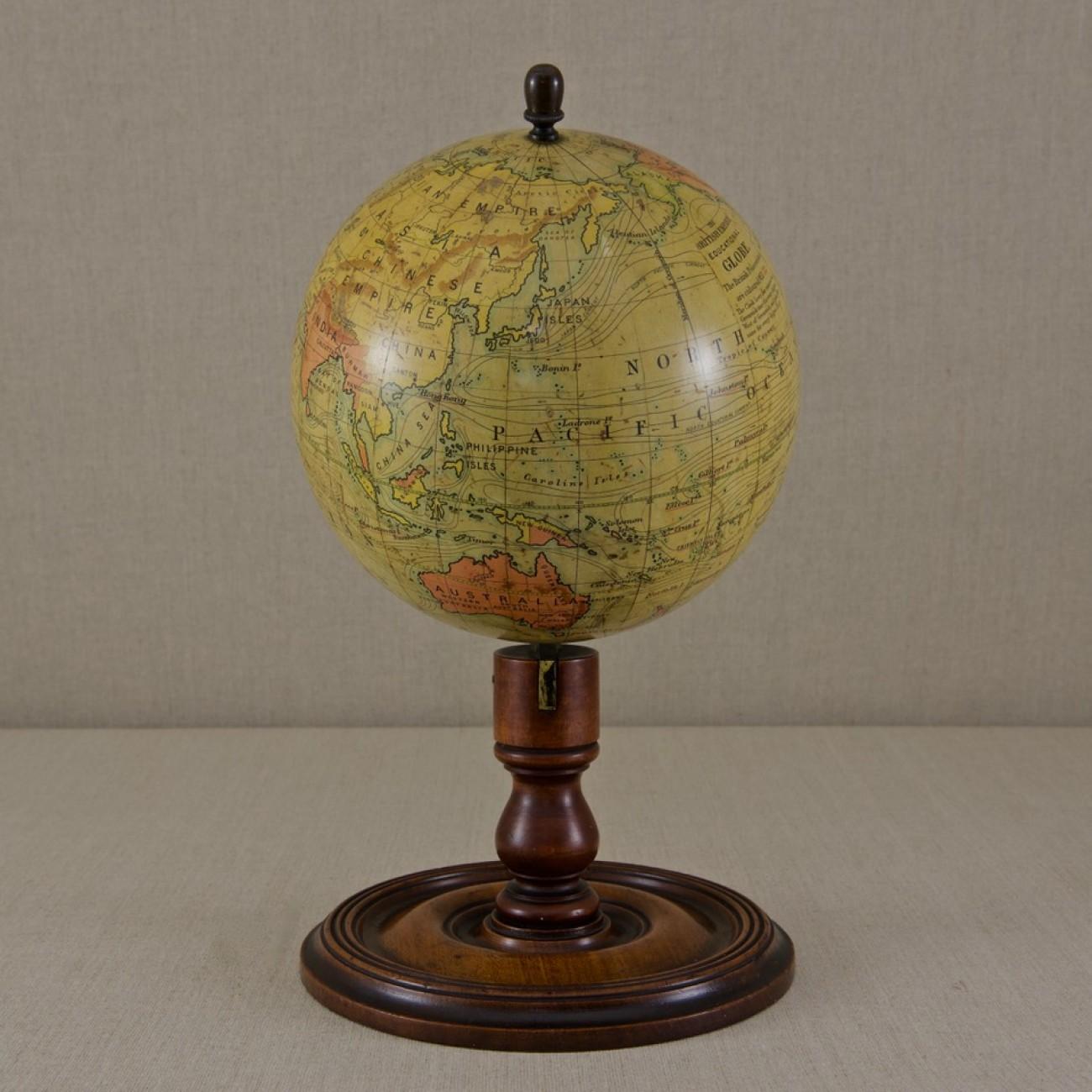 A handsome 8 inch terrestrial globe by C. Smith and Son printed in several colors presented on original turned mahogany base and upright, with brass mounting and secured with an acorn finial; circa 1890. The globe comprises of twelve coated