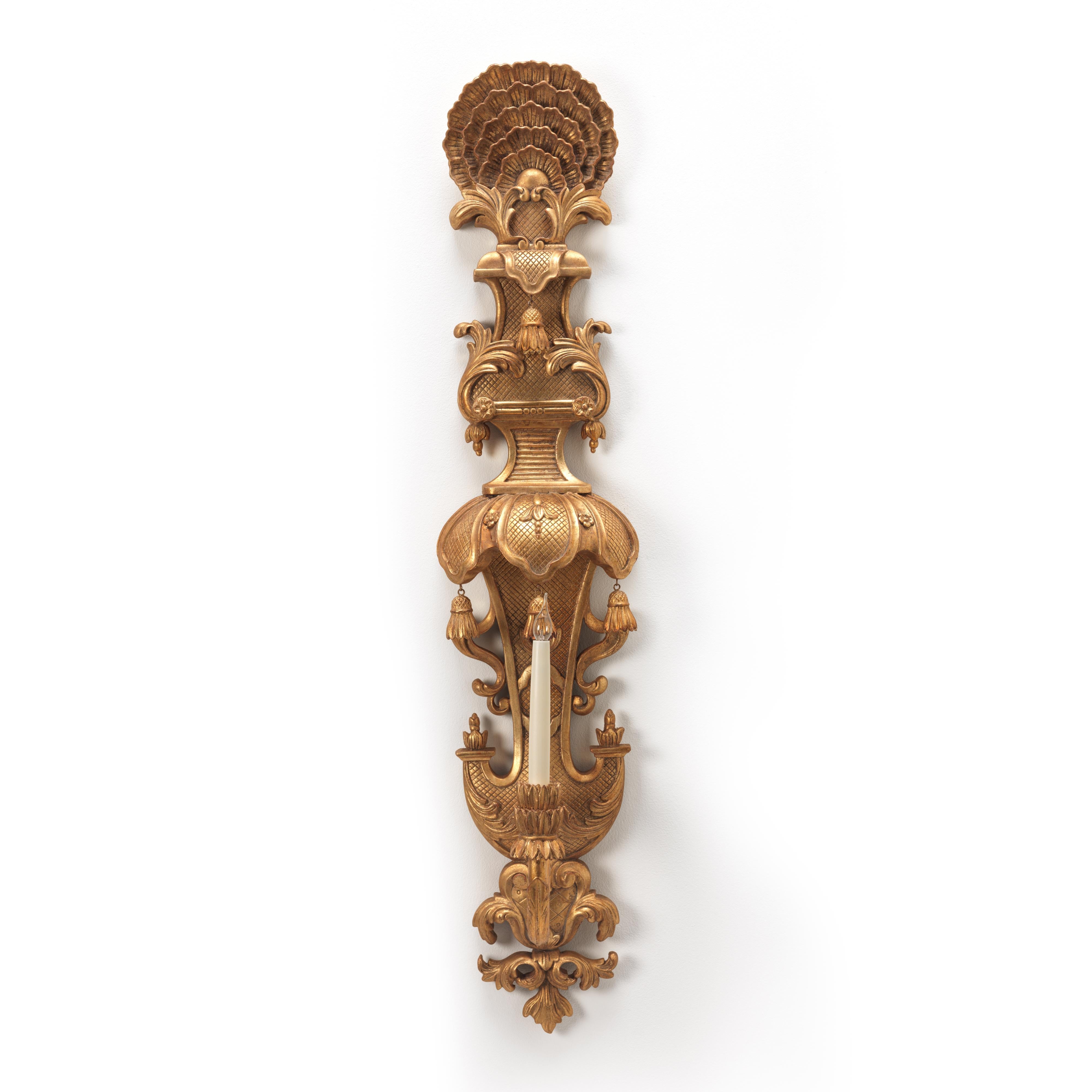 Belle applique William and Mary en bois sculpté et doré, à une seule branche. Le corps est sculpté d'un décor de glands et de sangles surmonté d'un motif de plumes de paon. Peut être fourni avec ou sans raccord électrique. Possibilité d'adaptation