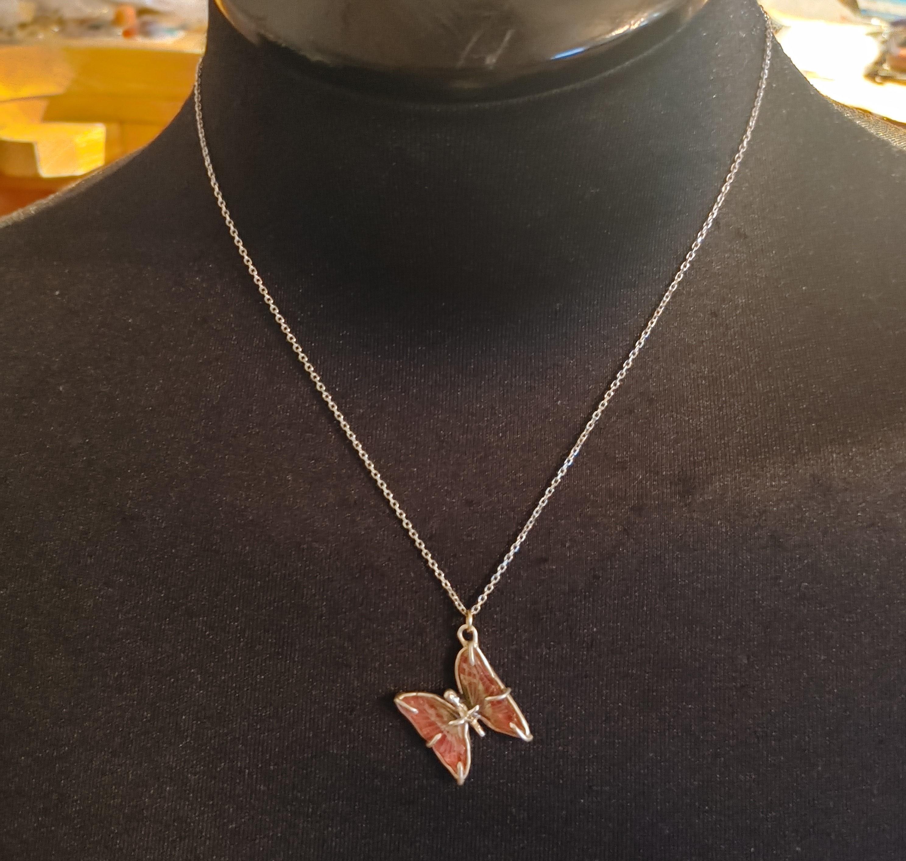 The Butterfly Necklace creates the illusion of a butterfly that is about to fly away, adding movement to an otherwise rigid piece. The Butterfly is made out of a carved Pink Tourmaline Wings with bits of green, being held together by prongs and the
