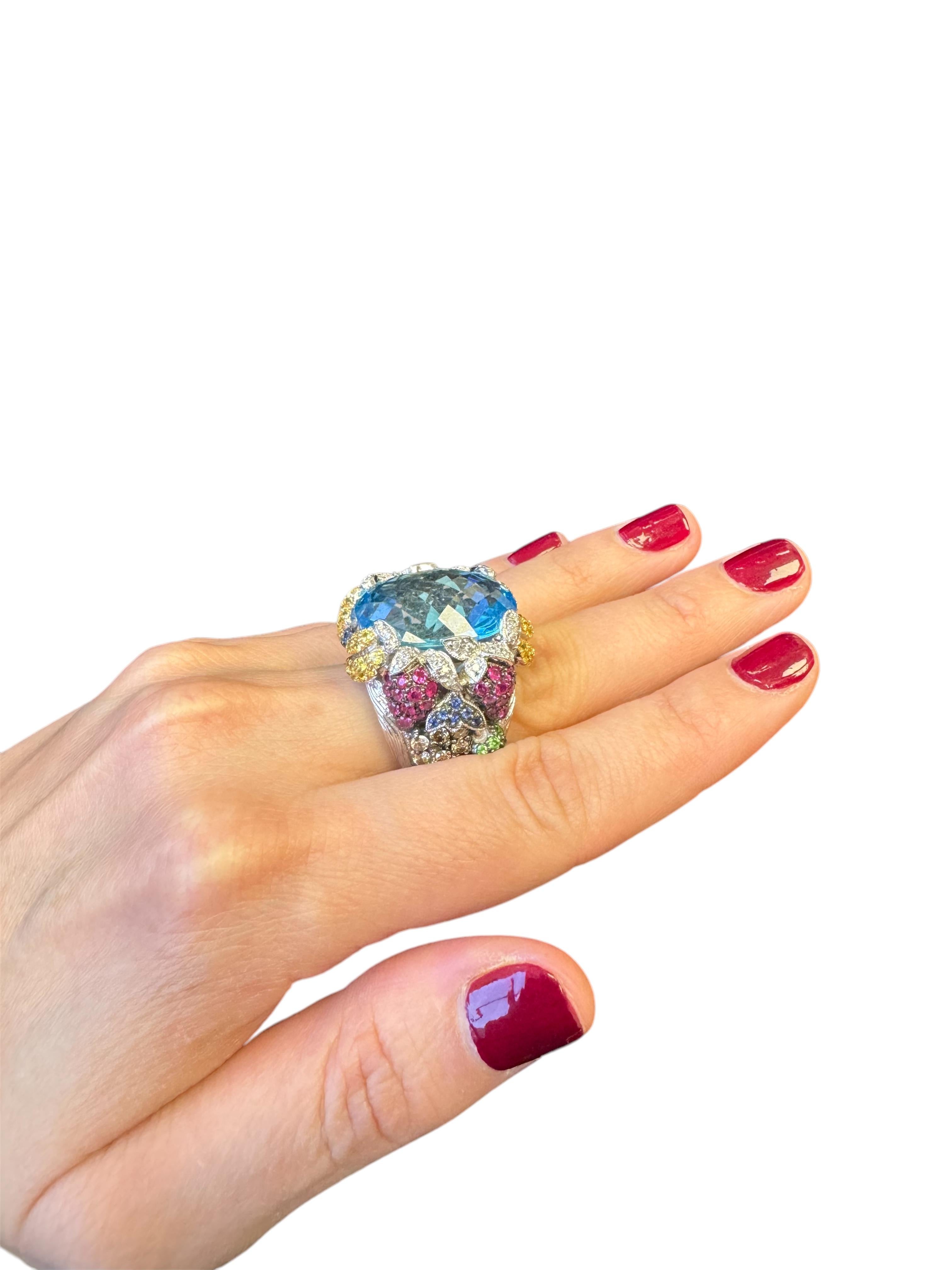 The Carmen Miranda Ring—a breathtaking vintage masterpiece circa 1990. Crafted from 14K white gold, this show-stopping piece features a stunning 16 x 22mm oval blue topaz with a mesmerizing checkerboard cut. Surrounding the centerpiece are sparkling