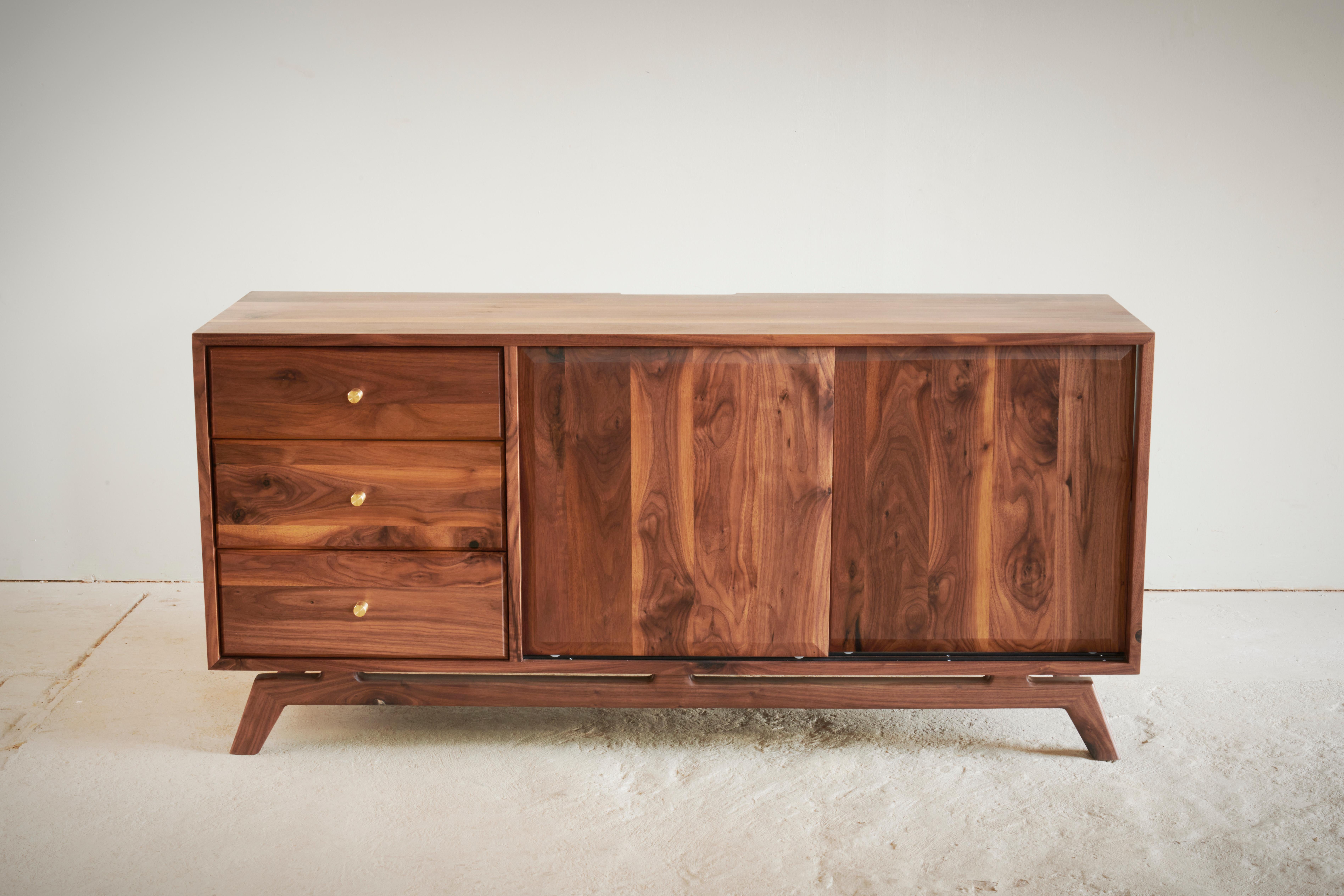 Discover the epitome of simplicity and sophistication with our Mid-Century Modern Walnut TV Unit. Crafted from sensuous walnut wood, this piece exudes a distinguished charm that effortlessly elevates your living space. Its design strikes a
