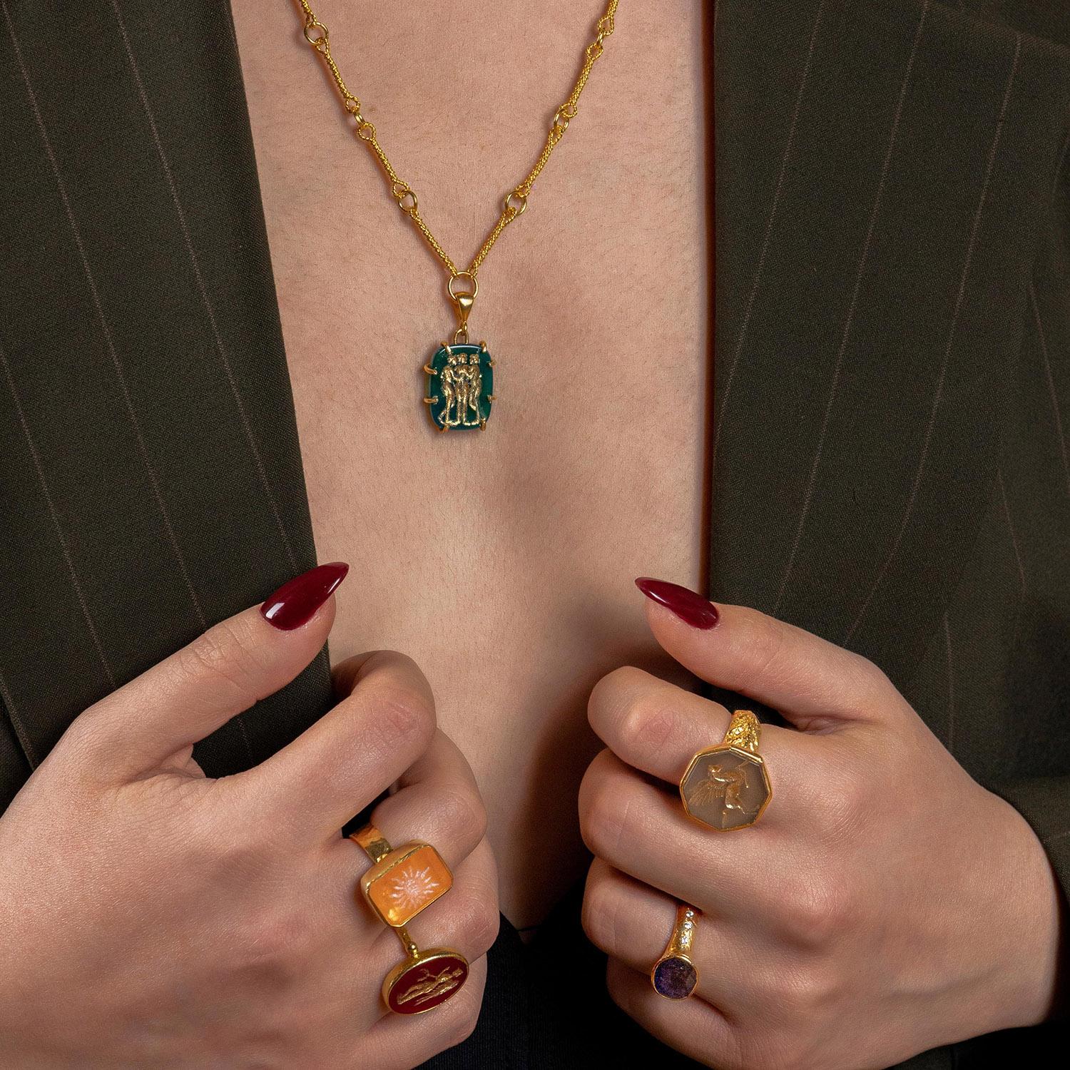 Das Collier Charites London ist nach drei Göttinnen benannt (Aglaia, Euphrosyne und Thalia, zusammen Charites genannt), die für natürliche Schönheit, Festlichkeit, Freundlichkeit und Charme stehen. Das handgefertigte The Charites-Intaglio auf dem