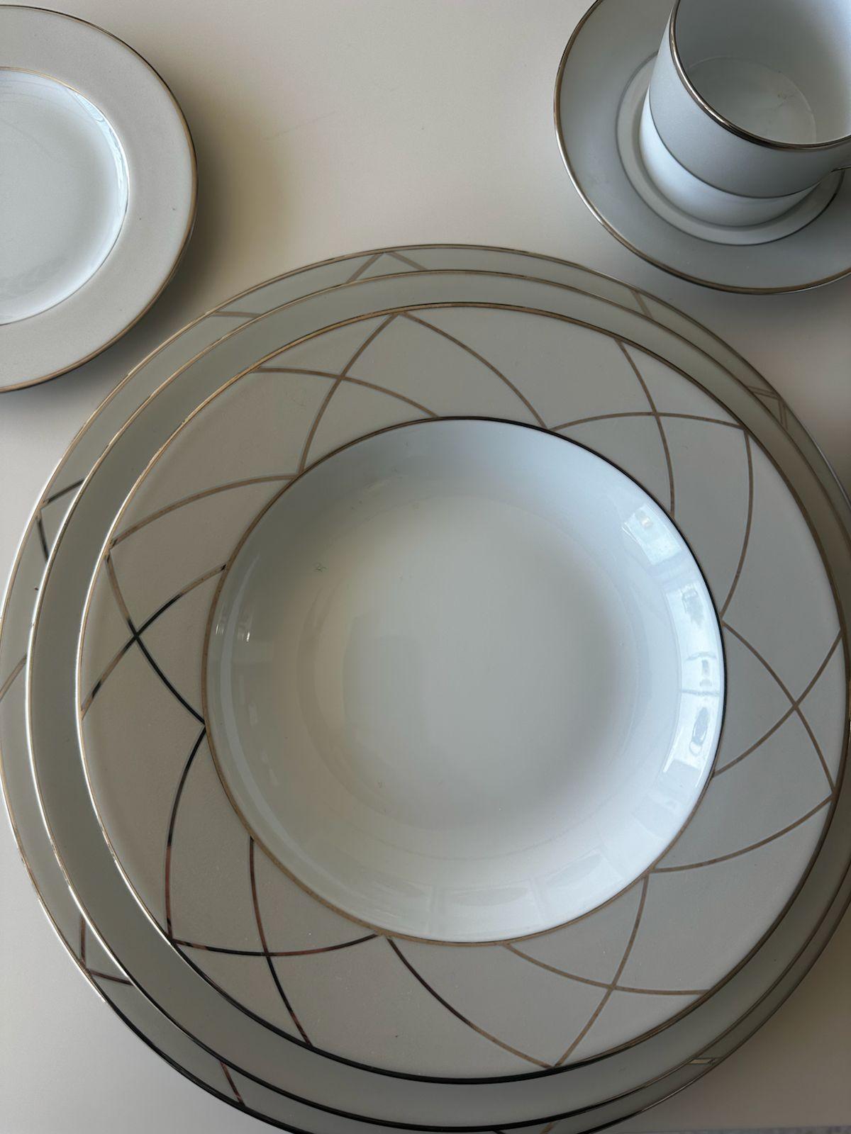The Clair de Lune collection is a chic and minimalist design from Maison Haviland. Its platinum arches on a pearl-gray background take inspiration from the Art Deco influences abundant in early 20th-century architecture and design. This iconic style