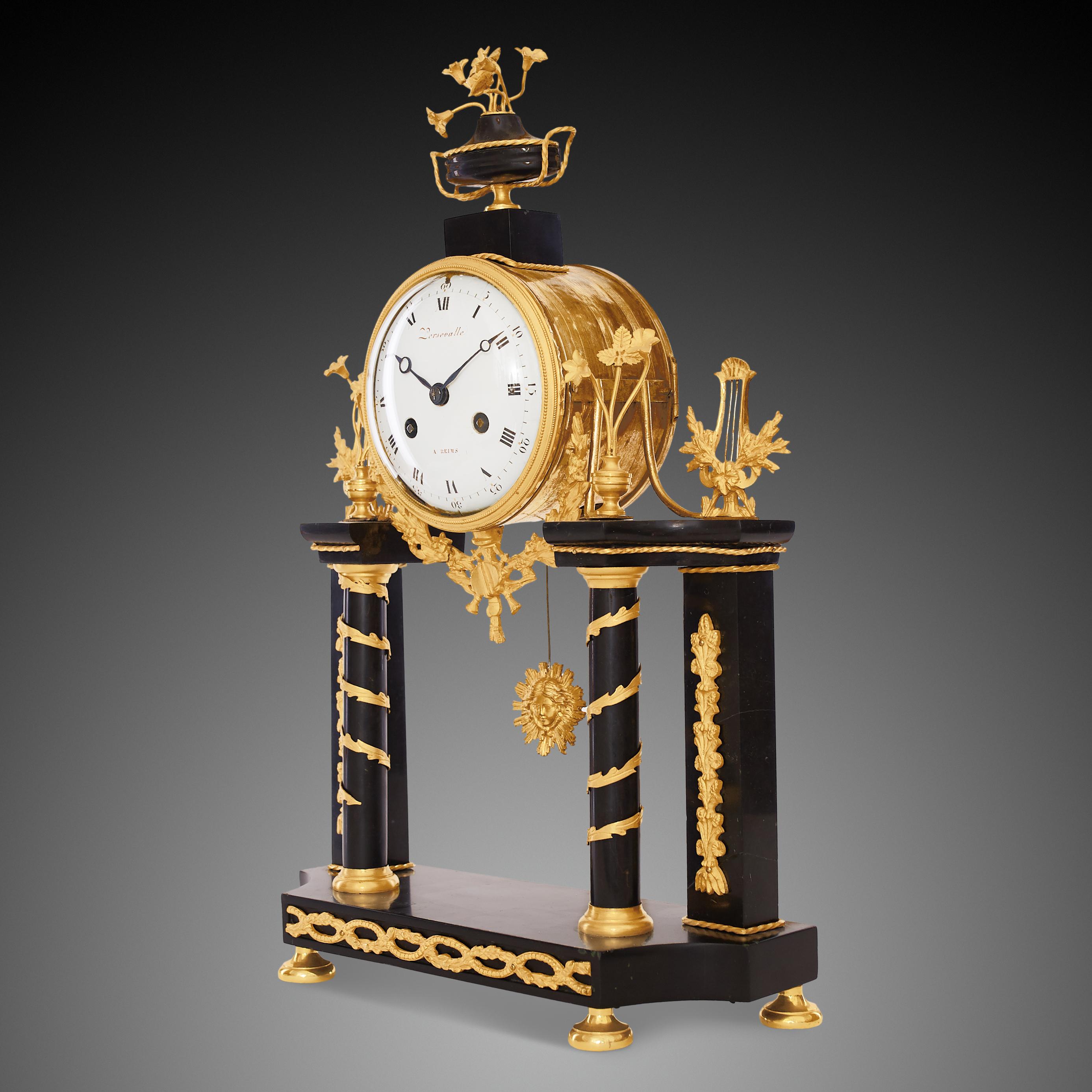 Portico clock signed “Persevalle à Reims”
This refined portico clock crafted in transitional Louis XVI – Empire style from ormolu and black marble is signed on the dial “Persevalle à Reims”. The Empire style was based on elements of the Roman
