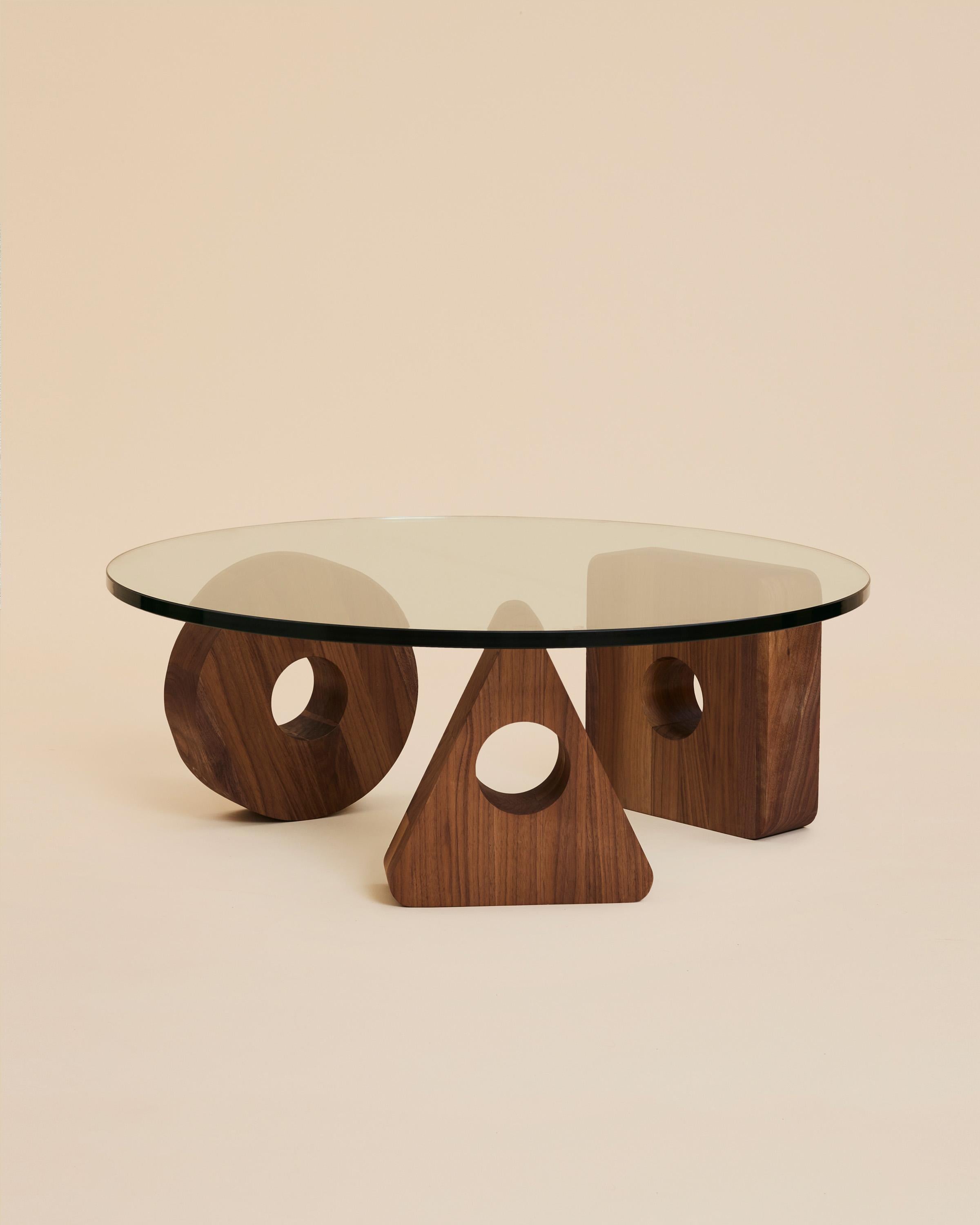 Meet Cosmo, the center of the ARJÉ furniture line. Revisiting the same symbolism as our walnut serving boards, this glass top coffee table rests on three hand cut walnut silhouettes, crafted by hand in Rochester, NY from black walnut harvested from