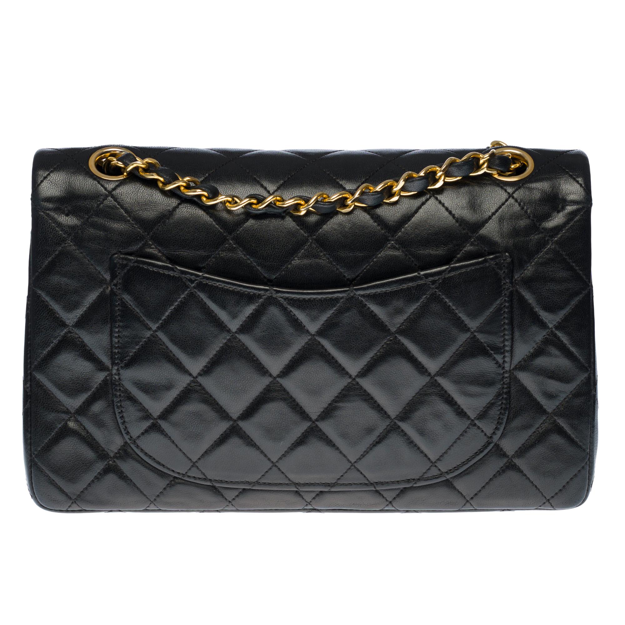 The coveted Chanel Timeless 23cm double flap bag in quilted black lambskin leather, gold metal trim, gold metal chain intertwined with black leather for shoulder and shoulder strap
Pocket on the back of the bag.
Flap closure, gold-tone CC