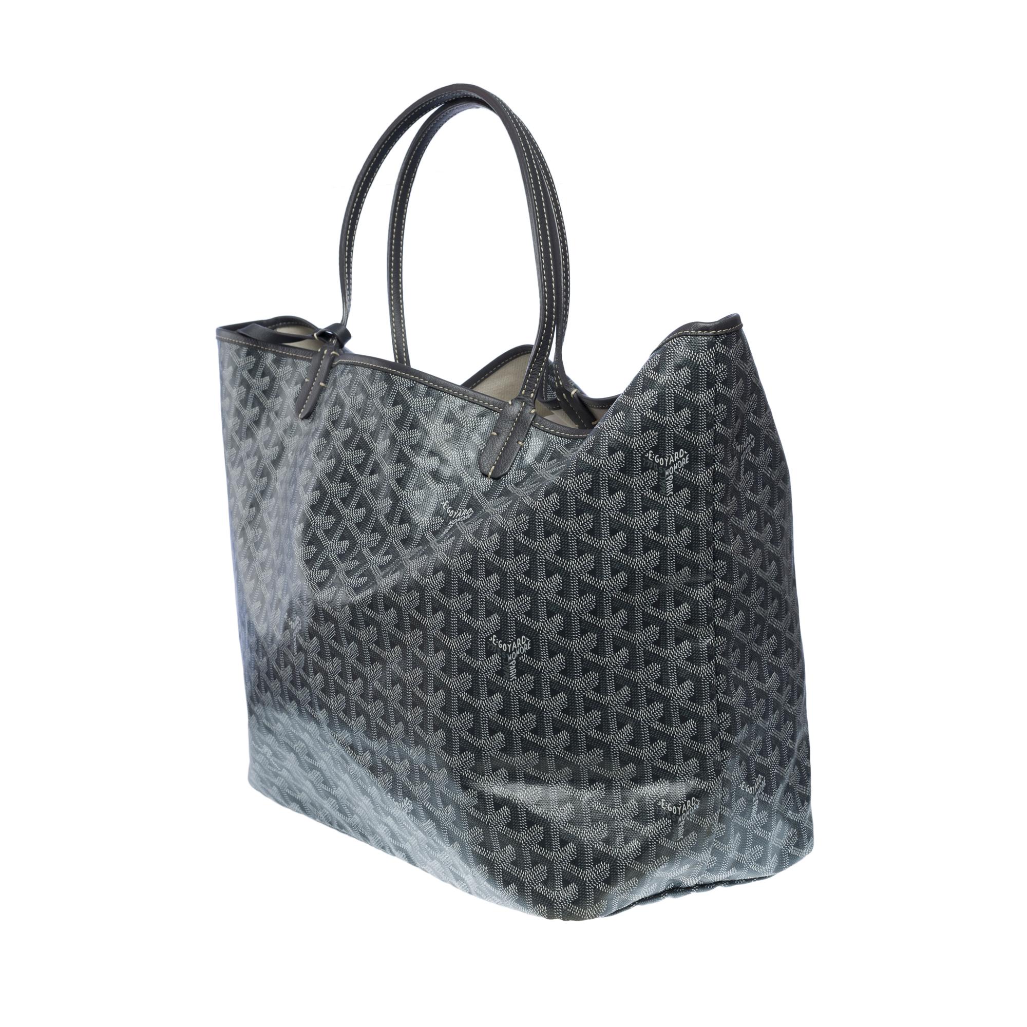 Sac cabas Goyard Saint-Louis GM (grand modèle) en toile de Goyardine grise et blanche et cuir gris, quincaillerie en métal argenté, double anse en cuir gris permettant un maintien à la main ou à l'épaule. 
Doublure intérieure en toile blanche, 1