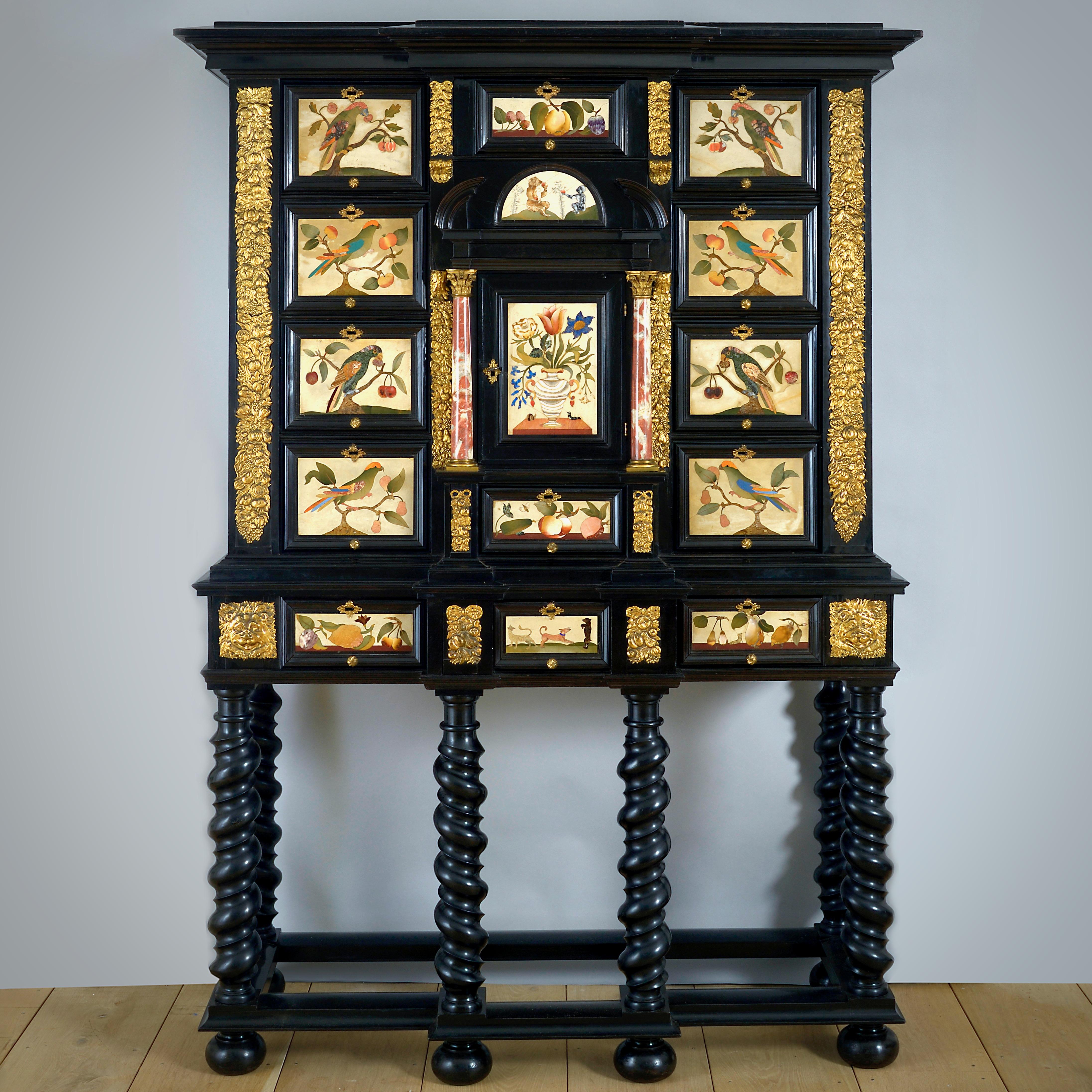 UN MAGNIFIQUE CABINET SUR PIED EN PIETRA DURA MONTÉ SUR LAITON, ÉBÈNE ET ÉBONITE, HOLLANDAIS, VERS 1650-80, LES PANNEAUX EN PIETRA DURA FLORENTINE, MILIEU DU XVIIE SIÈCLE.

L'ensemble est orné de deux tiroirs à panneaux en pietra dura de Florentine