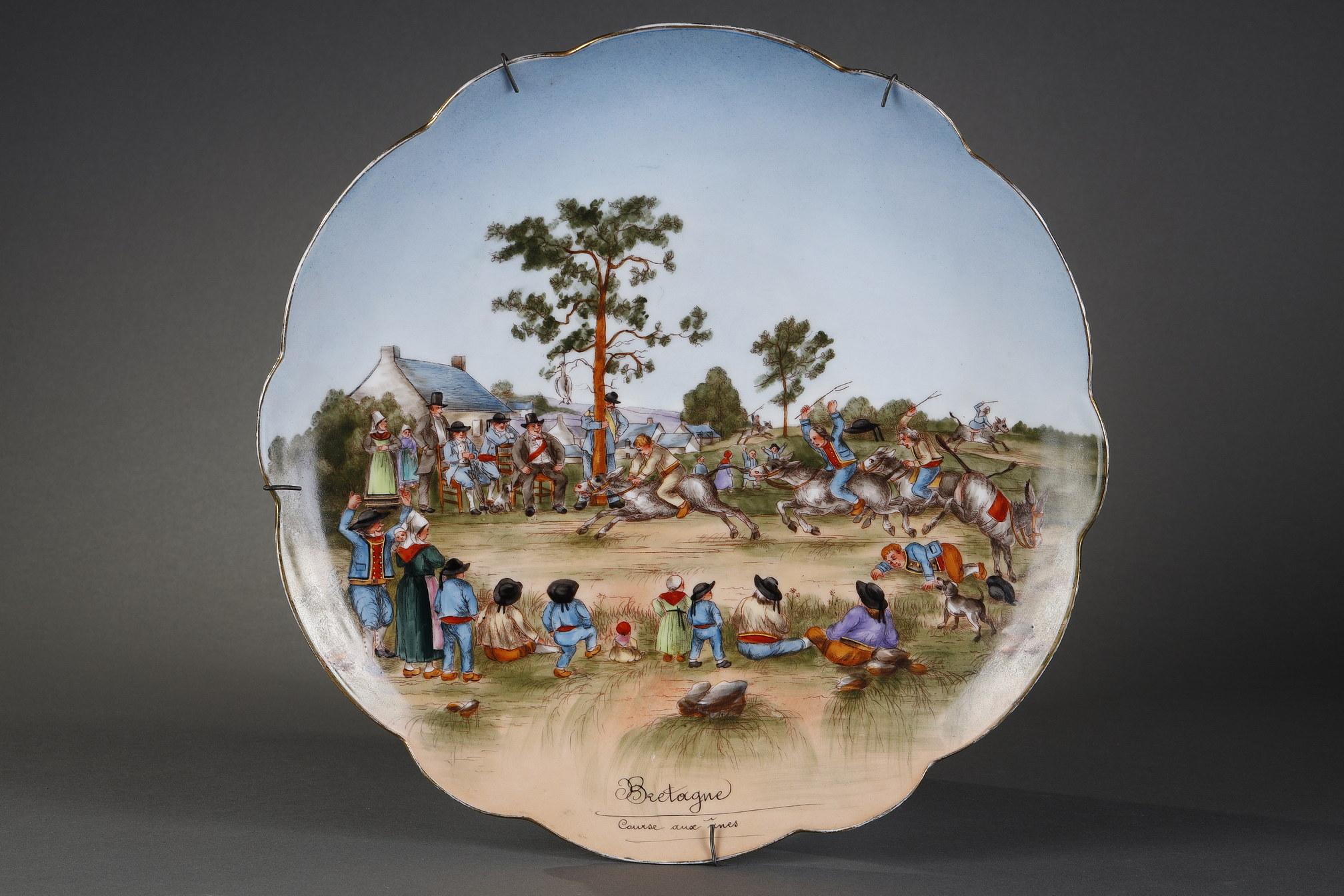 Charming Limoges porcelain dish with scalloped edges representing a popular festival, a donkey race in a village in Bretagne, attended by families in traditional outfits. 

Maximilien-Ferdinand Mérigot (1822-1892) is a French porcelain painter who