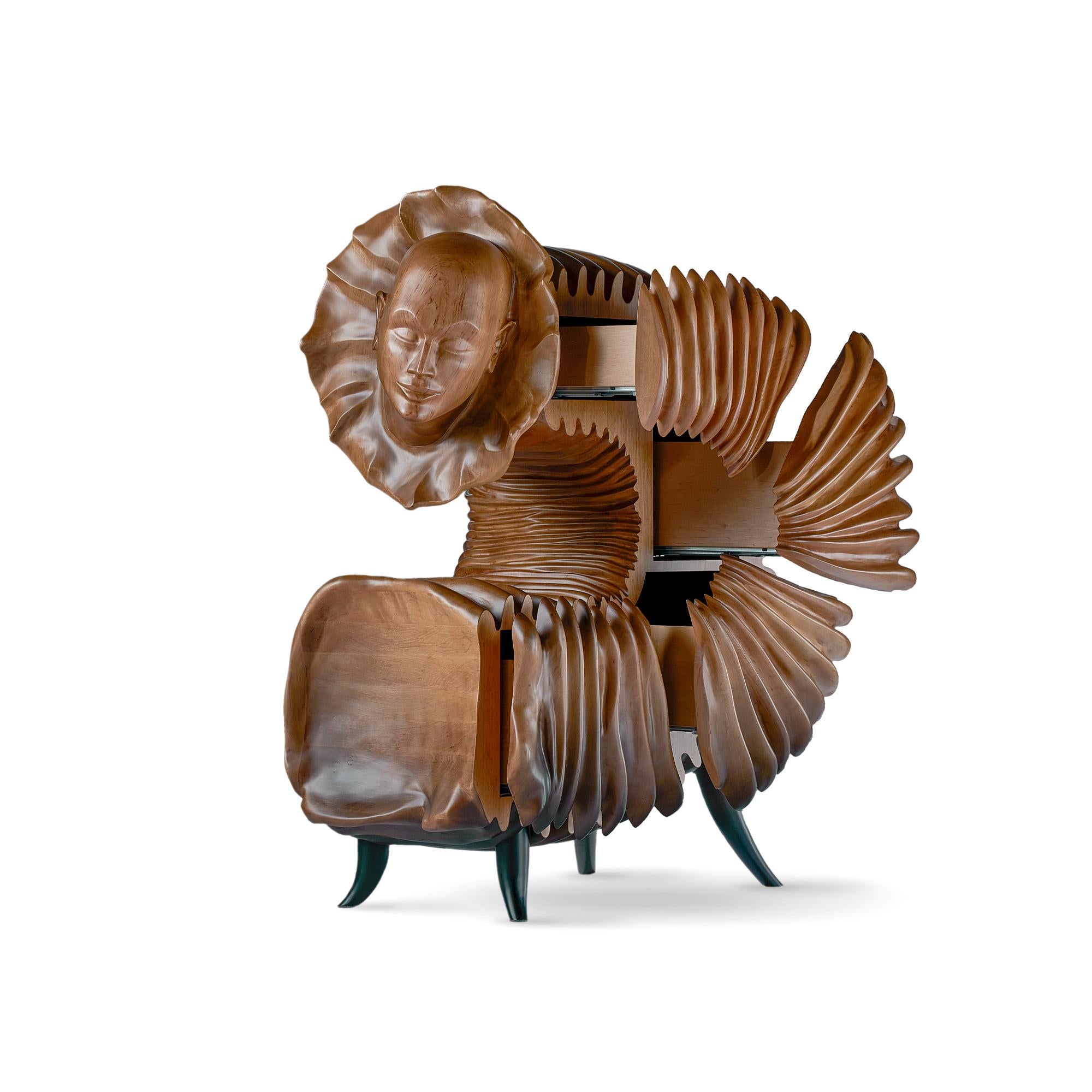 Wooden sculptural cabinet ' The Dreamer ' is a work of enormous charisma possessing the qualities and charm of poetry. Symbolic thought is encoded using a realistic sculpture technique accompanied by surreal imagination. The dreamy face of a woman