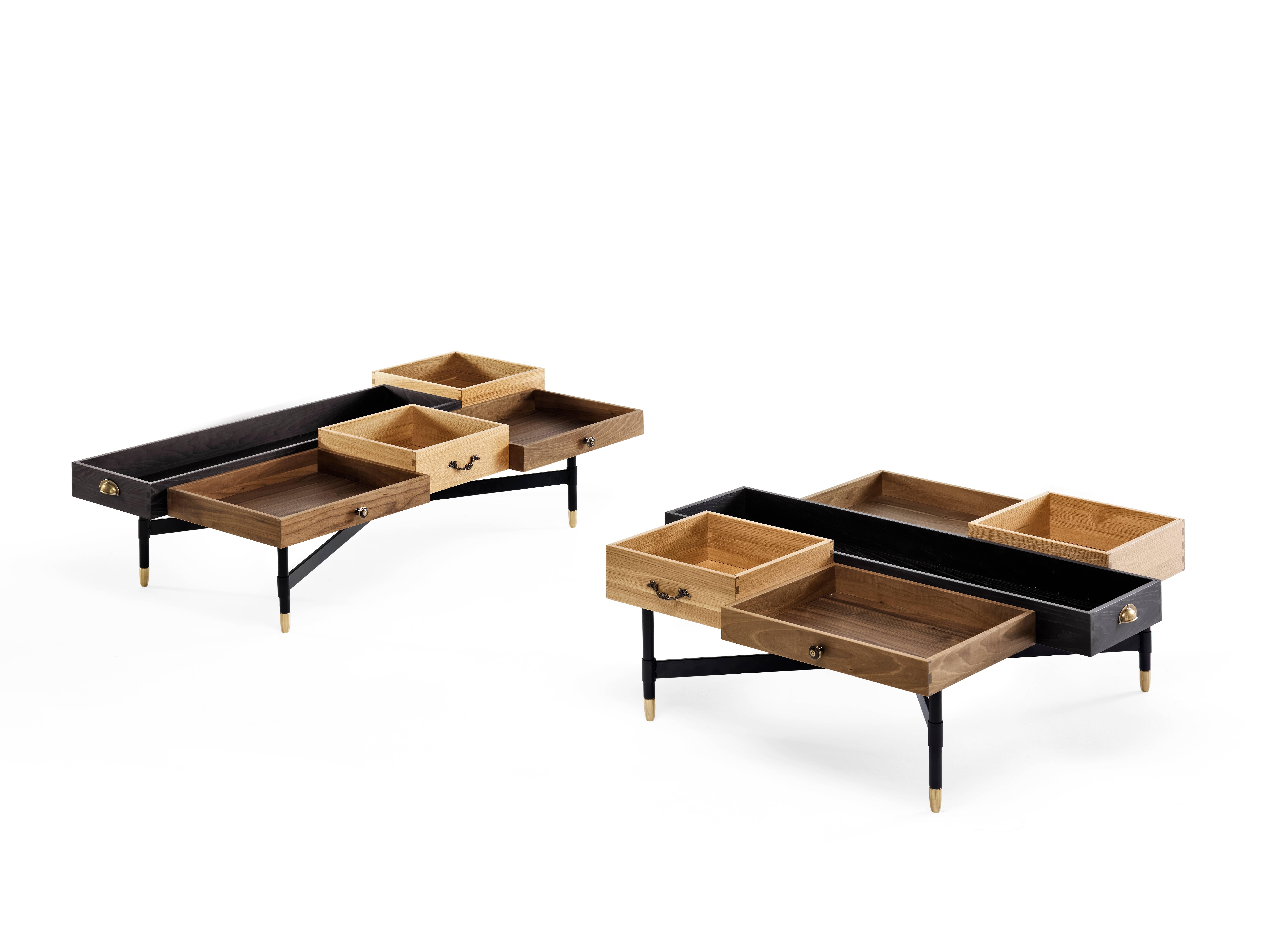 The Dreamers est une table basse conçue par Uto Balmoral pour Mogg, réalisée en noyer, frêne et chêne massif. The Dreamers sont une paire de tables basses composées de tiroirs, l'idée de la création de ces tables basses est basée sur la 