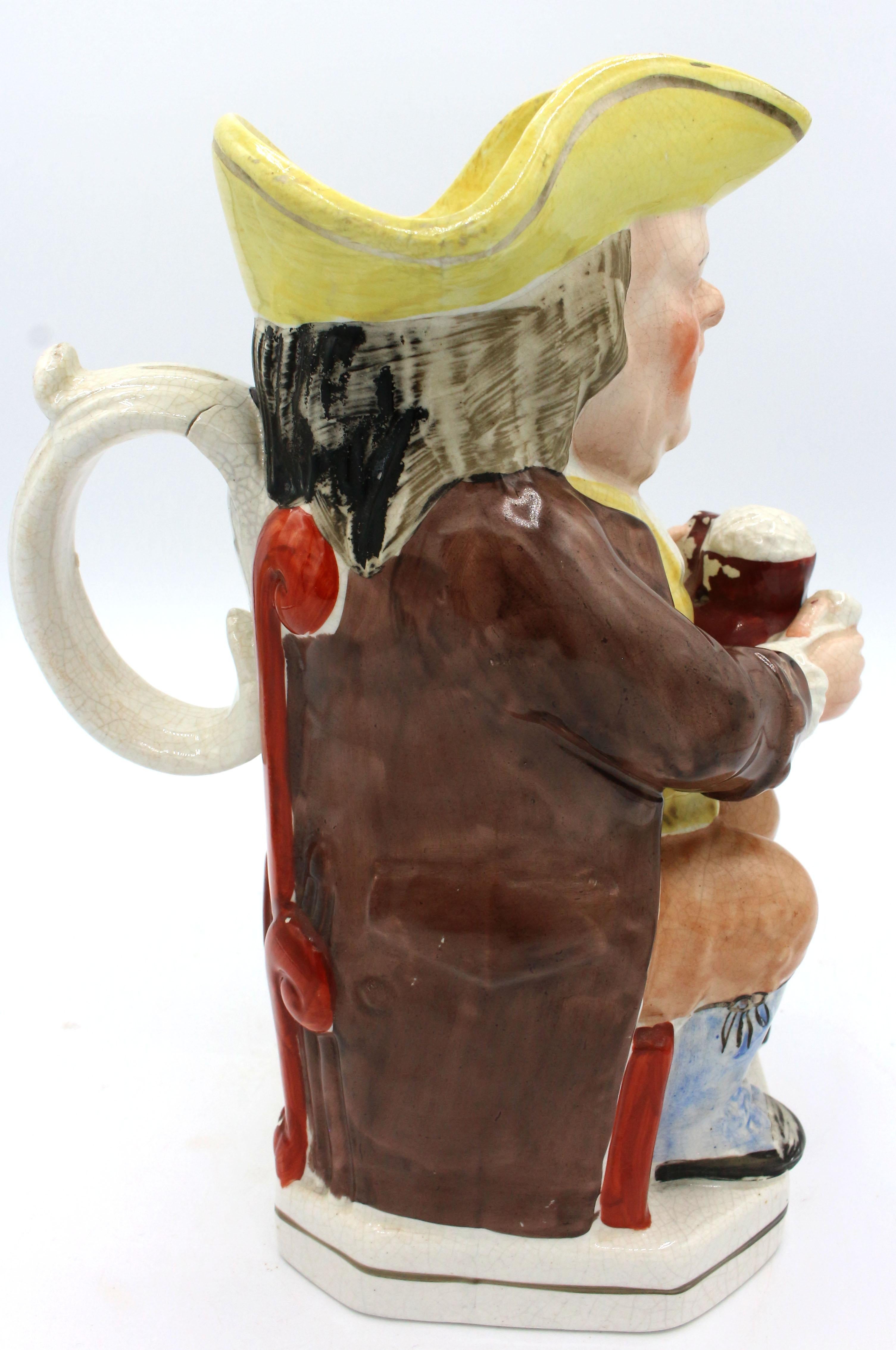 Le Parsons ivre avec un col clérical blanc Toby Jug, Angleterre, vers les années 1880. Staffordshire. Glaçure craquelée et défaut de cuisson dans la poignée. Il tient une tasse mousseuse et une pipe.
10