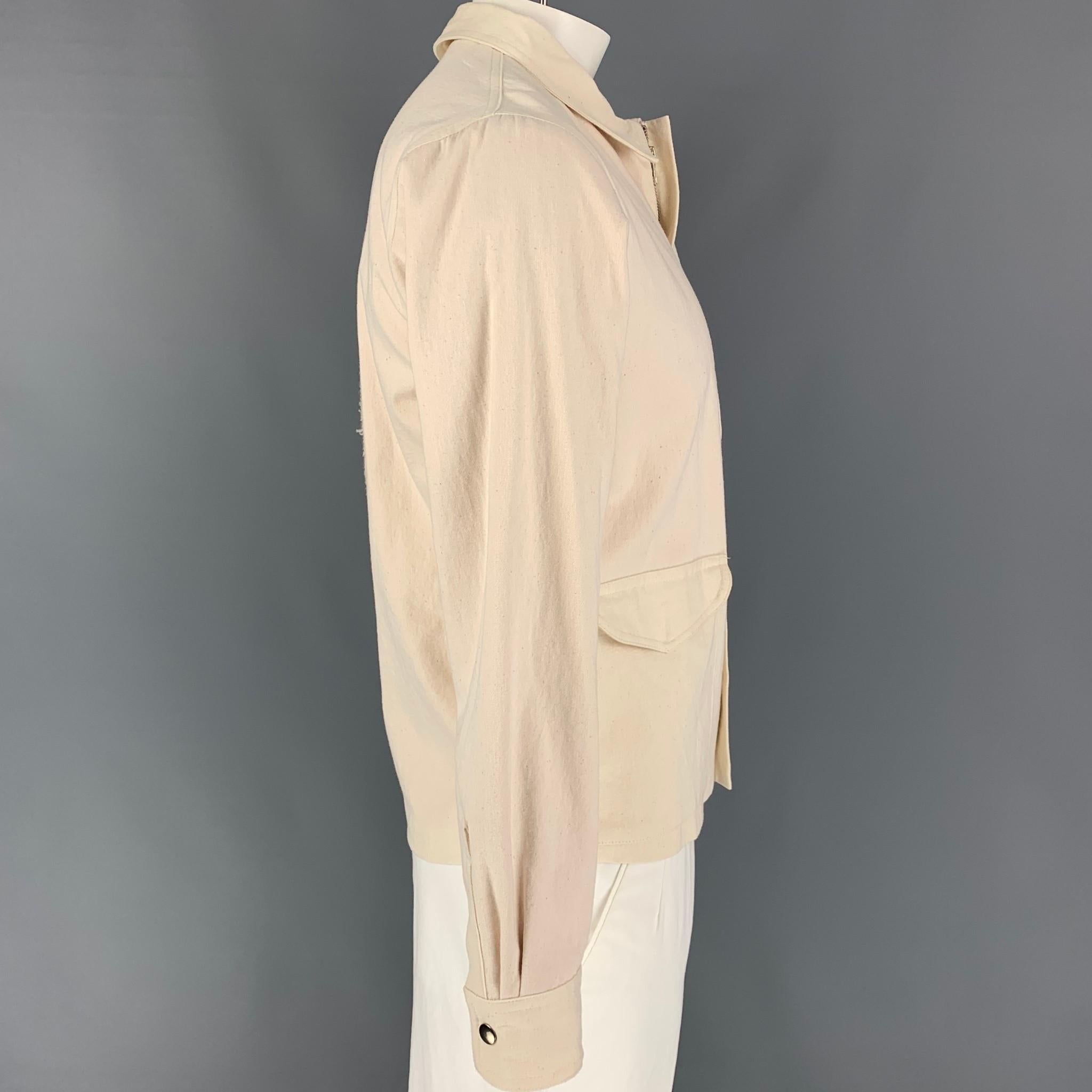 THE ELDER STATESMAN jacket comes in a beige cotton with a pink lining featuring a back cactus embroidered design, large patch pockets, spread collar, and a hidden zip up closure. Made in USA. 

Excellent Pre-Owned Condition.
Marked: