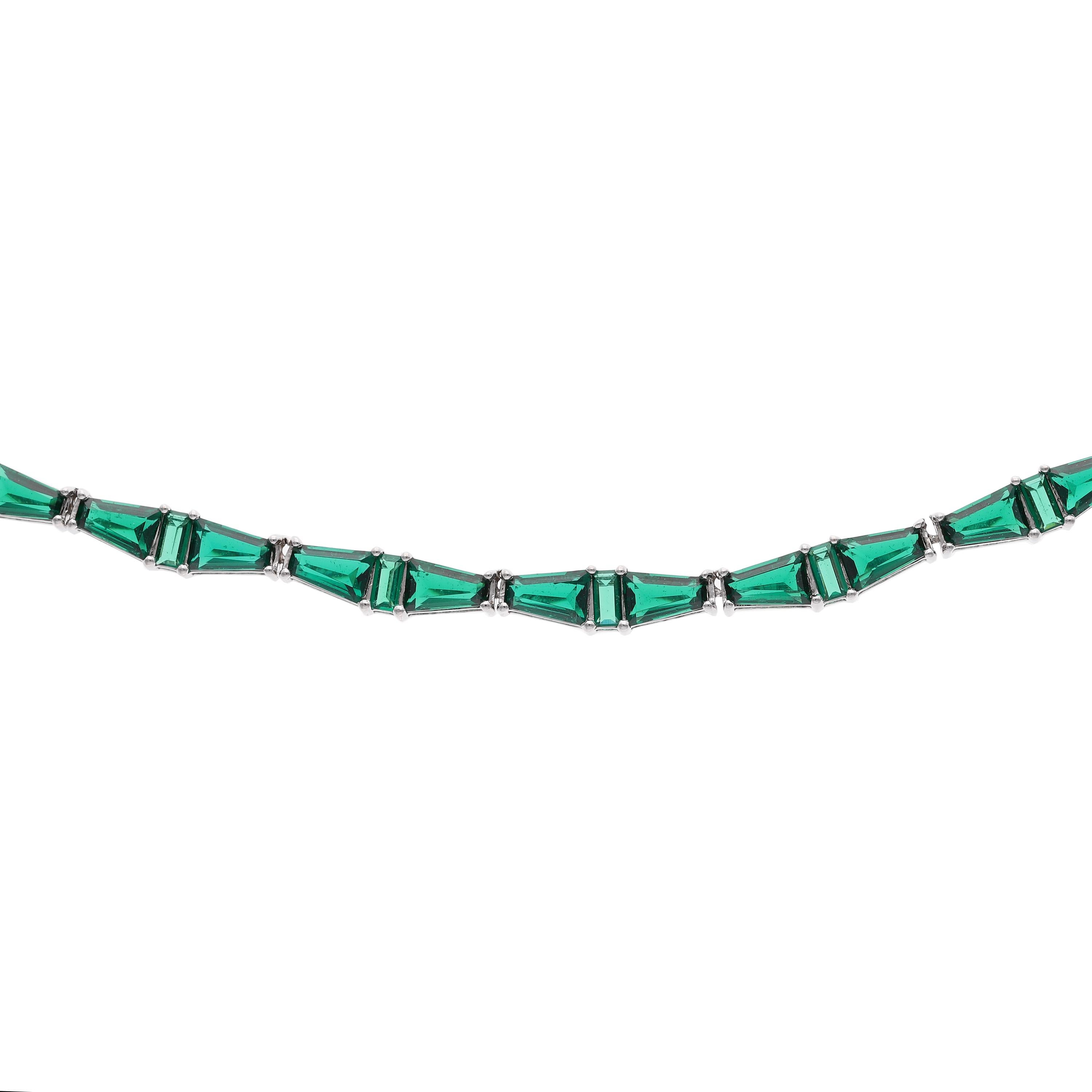 Featuring sixty-six individually hand cut lab emeralds, this choker is something out of Daisy Buchanan’s dreams. An assortment of baguette emeralds, this choker is a pattern of elongated and tapered baguettes that sit elegantly along the collarbone.