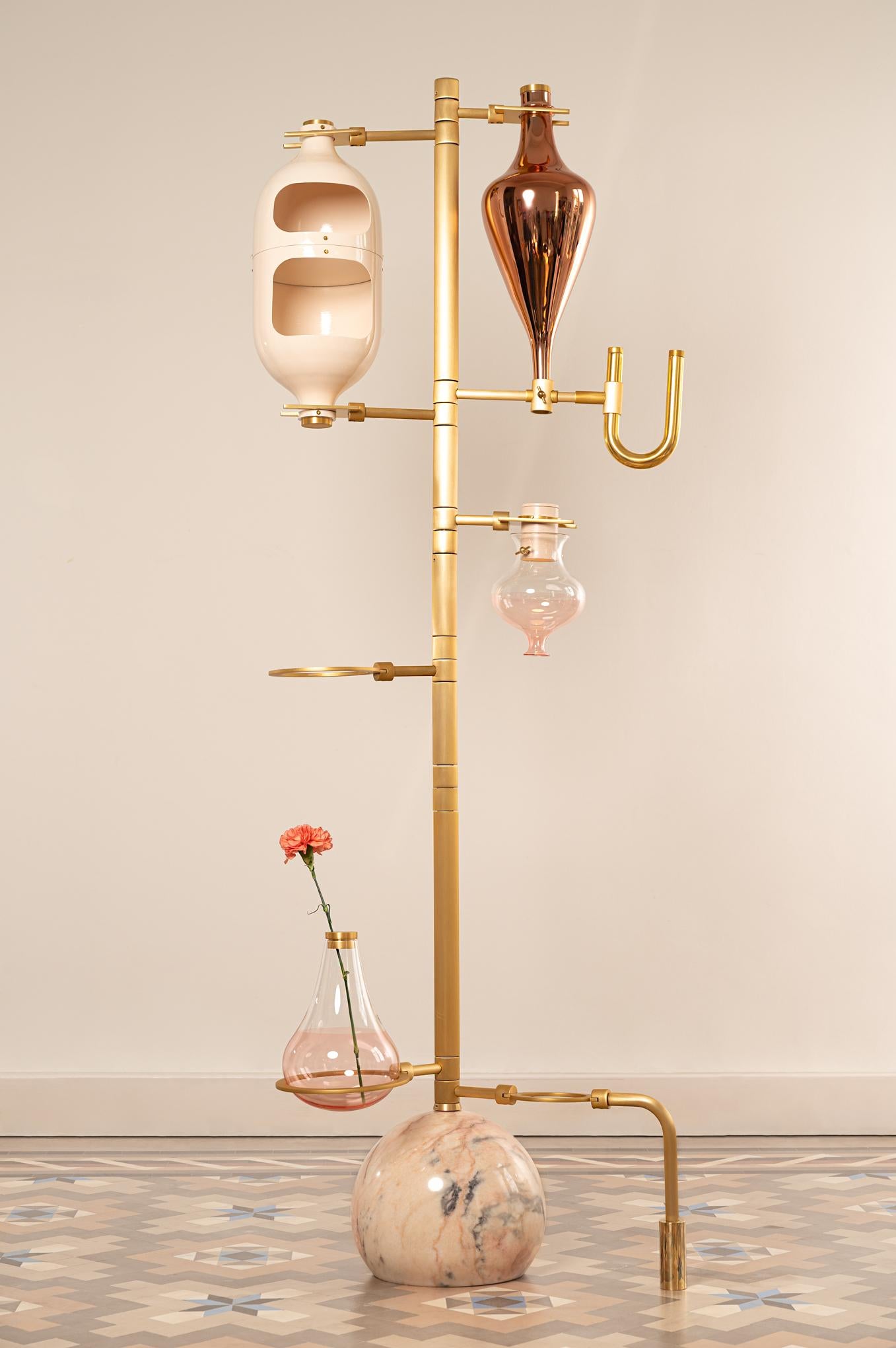  Interior designer Hania Jneid looked to chemistry sets when designing her elaborate floor lamp, named the Emotional Lab light.

The Emotional Lab floor lamp consists of a slender metal stand supporting several beaker-like glass vessels that light