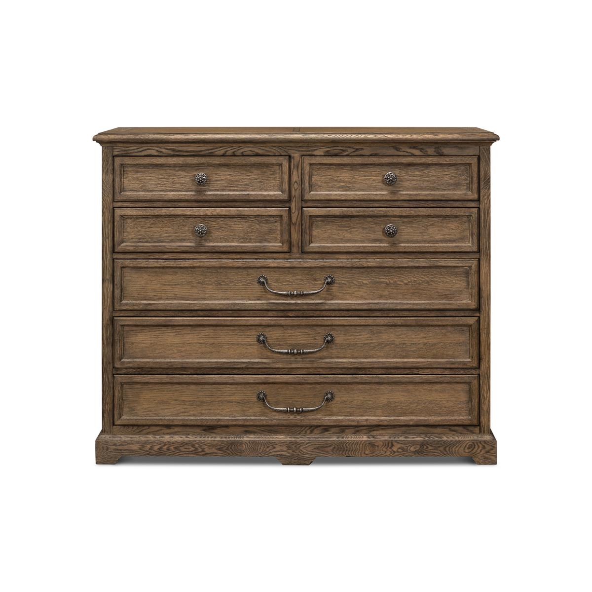 This elegant and grandly scaled iteration in a husk finish is crafted in oak crown veneer with all the hallmarks of furniture craft and quality construction. Bold, masculine, and fitted with seven drawers and exclusive cast iron