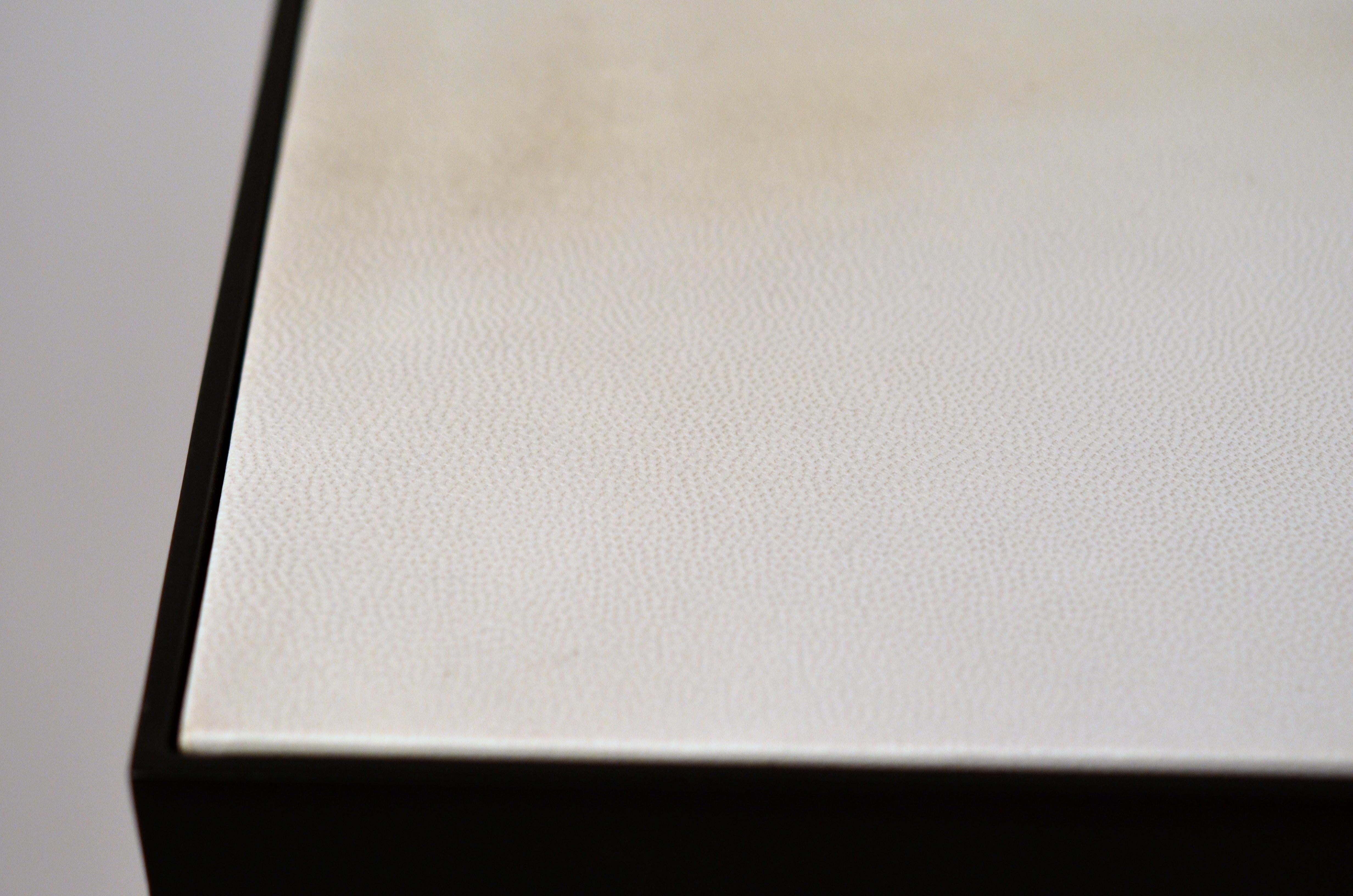 Schicke Konsole 'Esquisse' aus Schmiedeeisen und elfenbeinfarbenem Pergament von Design Frères. Kontrastierende elfenbeinfarbene Ziegenpergamentplatte über schlankem, geschwärztem Stahlsockel. Schönes, schlichtes, zurückhaltendes Design.