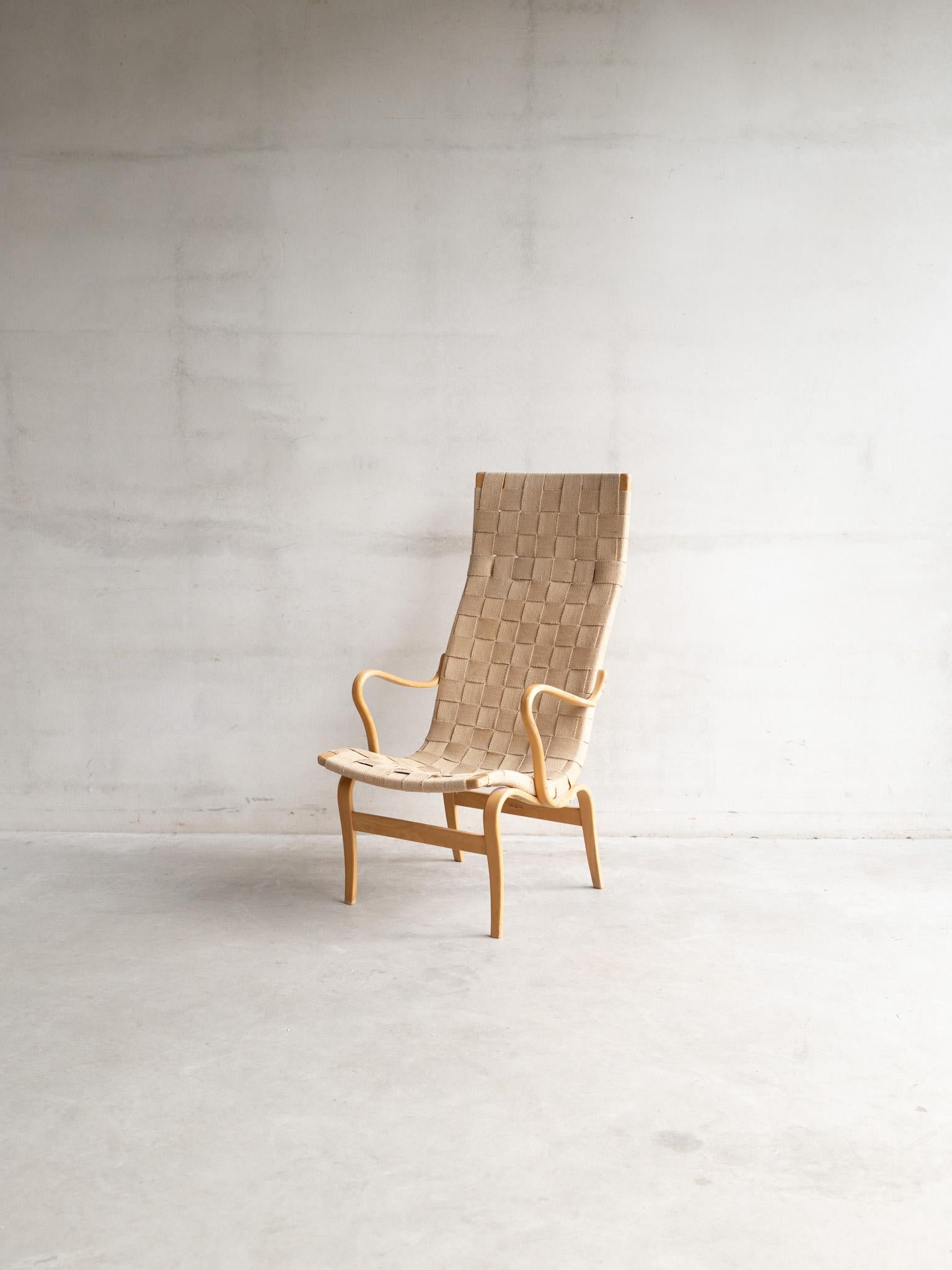 Der Eva Chair, ein Entwurf des berühmten schwedischen Architekten und Designers Bruno Mathsson aus den 1930er Jahren, ist ein Meisterwerk an funktionaler Eleganz. Der aus massivem Birken- oder Buchenholz gefertigte, fließend geschwungene Rahmen