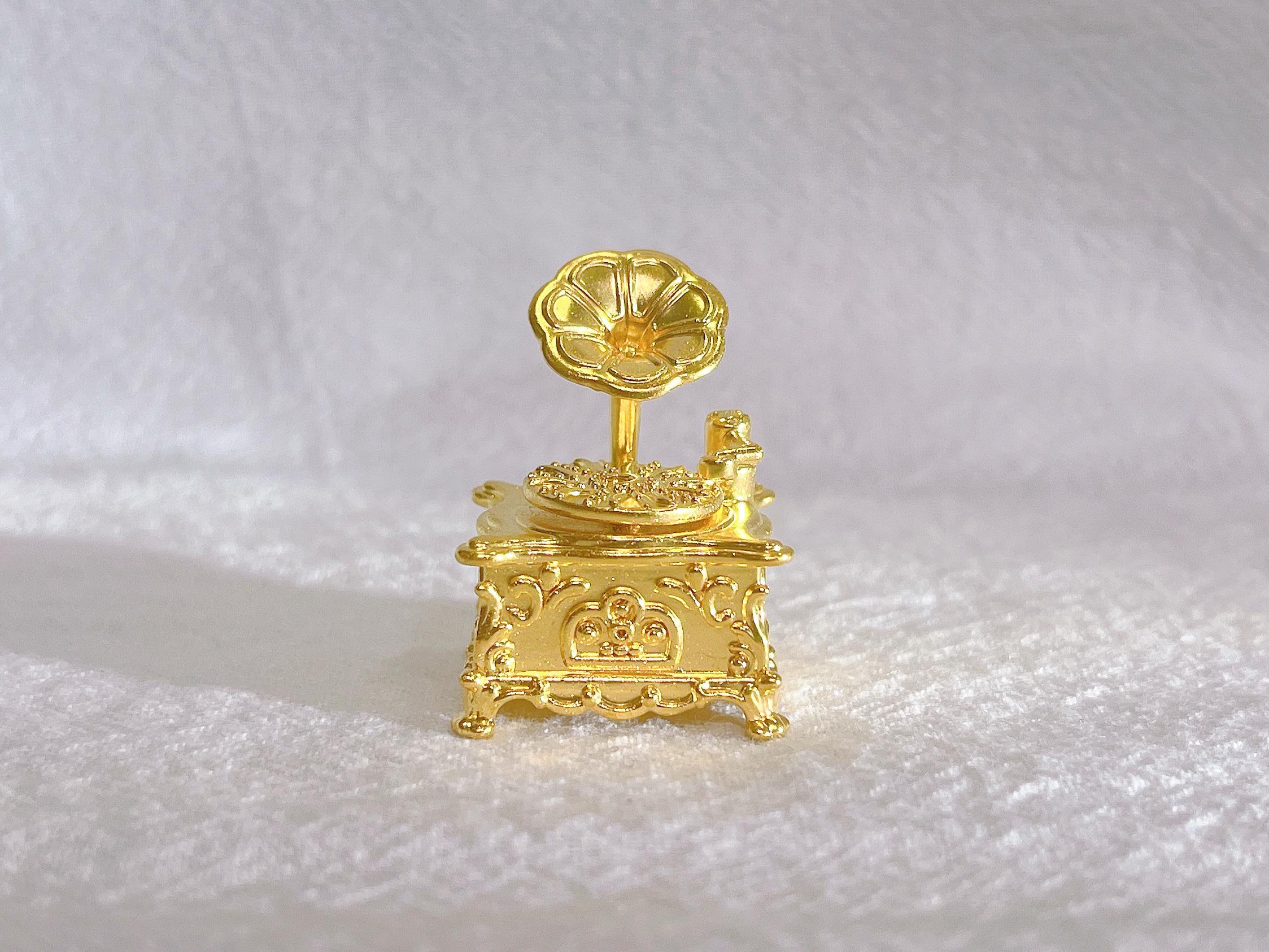 Dieses exquisite Au999 Grammophon-Ornament aus reinem Gold (6,08 Gramm) ist aus 999%igem Feingold gefertigt und reproduziert akribisch jedes Detail antiker Grammophone, einschließlich des ikonischen Horns und des Plattentellers mit Präzisionsgravur.