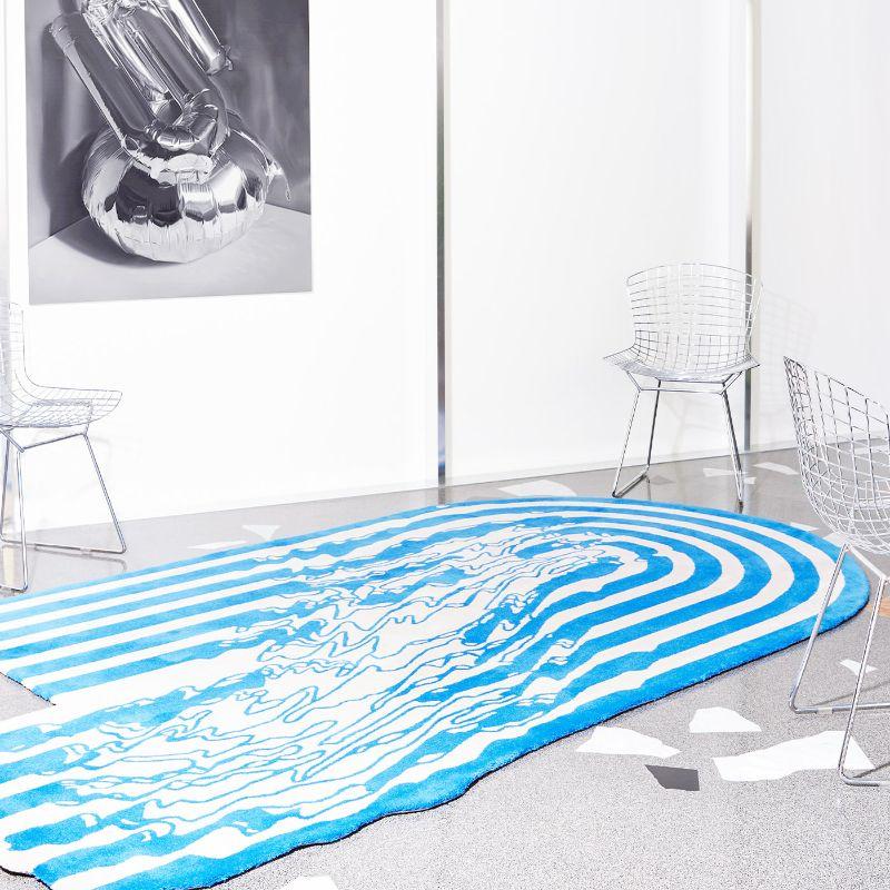 Stimulant par son motif asymétrique de rayures bleues et blanches, ce tapis touffeté à la main associant la laine de Nouvelle-Zélande et le lyocell Tencel appartient à la collection 