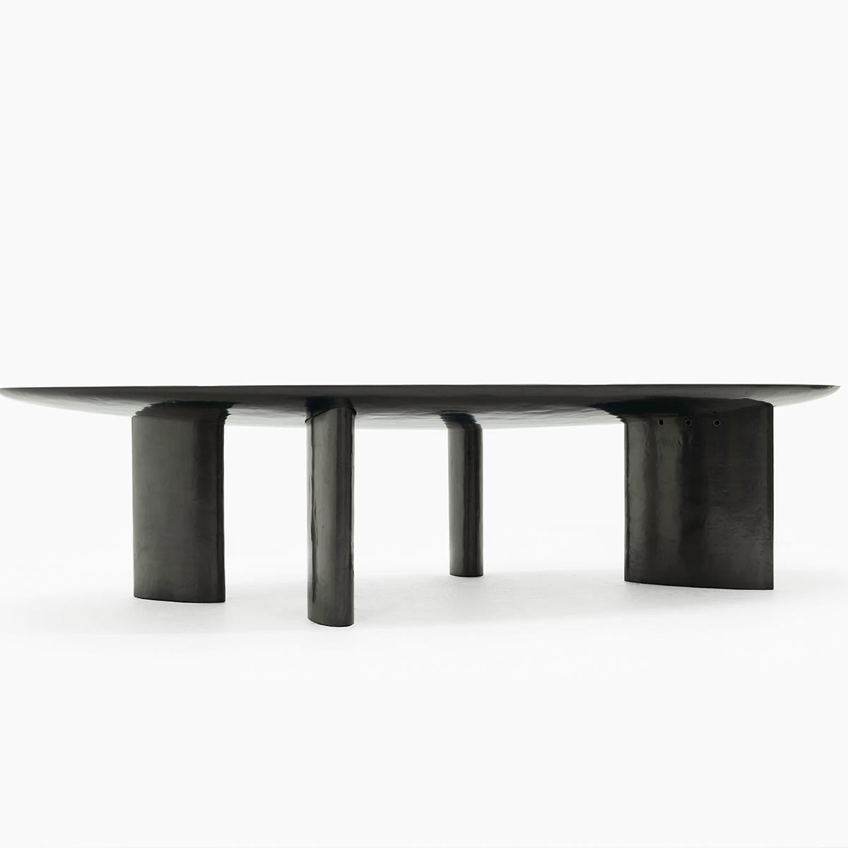 Four uniquely sized ellipse shaped base legs provide a uniquely asymmetric equilibrium to cradle the rounded underside of the magnificent plateau of this large center dining table. The finish of the top of the table is created with a mixture of